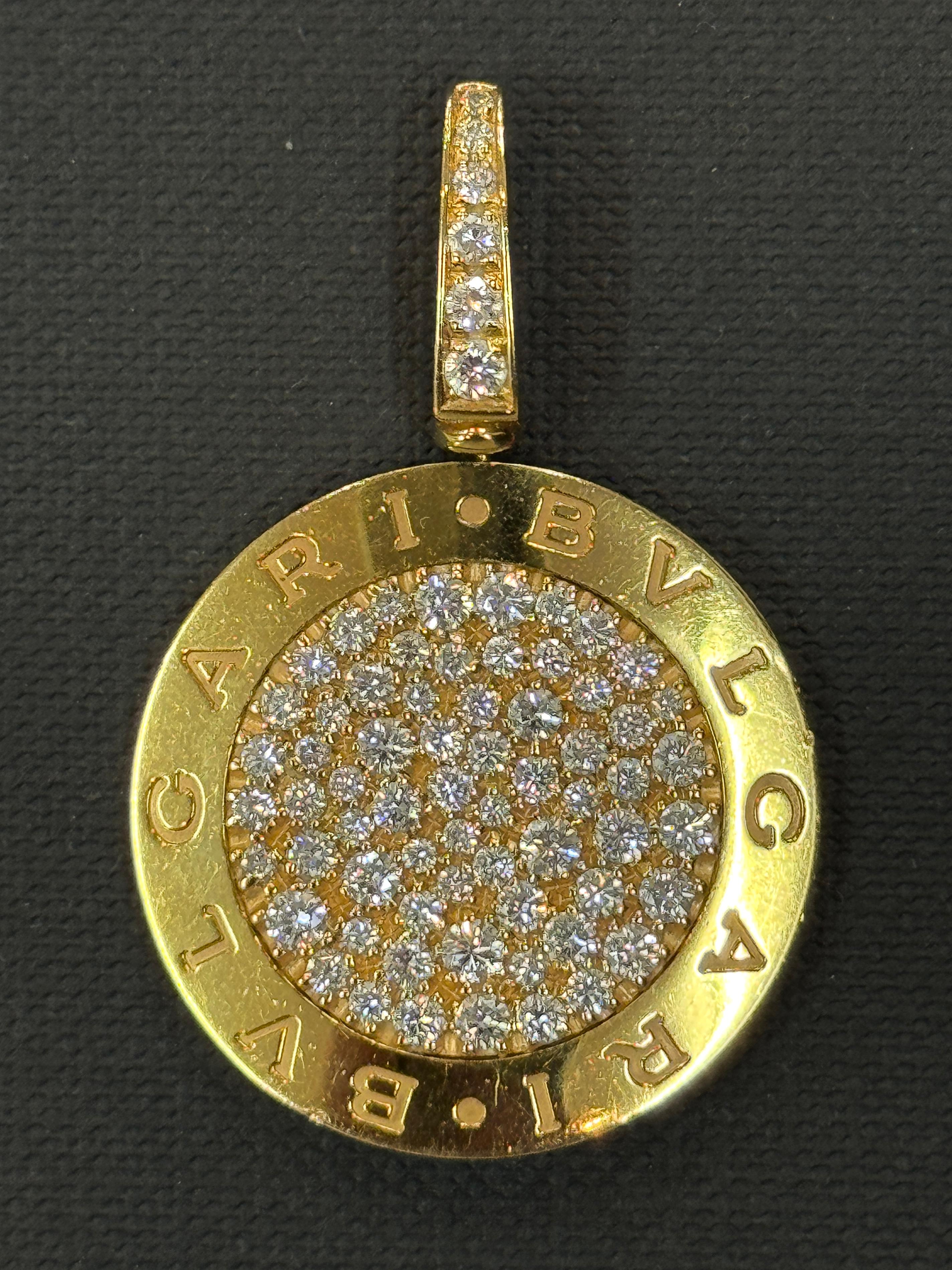 GRANDE CIONDOLO BVLGAEI IN ORO GIALLO 18 CARATI E CON UNA BALLA MOBILE A CERNIERA PER ADATTARSI A UNA CATENA DI SPESSORE FINO A 10 mm.

È INCASTONATO CON 72 DIAMANTI ROTONDI TAGLIO BRILLANTE GRADUATI DA 1,5 A 6 PUNTI (DA 0,015 A 0,06 CARATI) PER UN