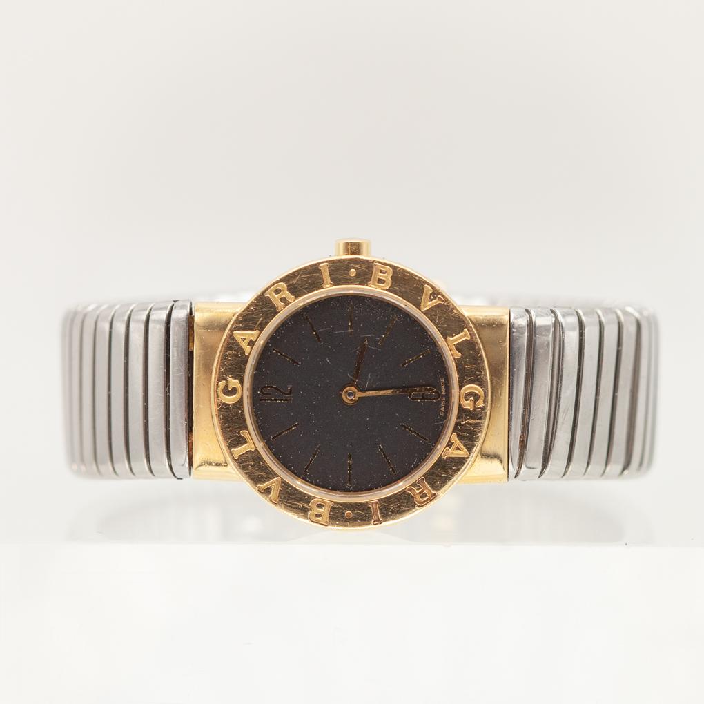 Diese ikonische Bulgari Tubogas-Armbanduhr aus Edelstahl und 18-karätigem Gelbgold verfügt über ein 26-mm-Gehäuse mit der charakteristischen BVLGARI-Gravur auf der Lünette und umrahmt ein minimalistisches schwarzes Zifferblatt mit dezenten