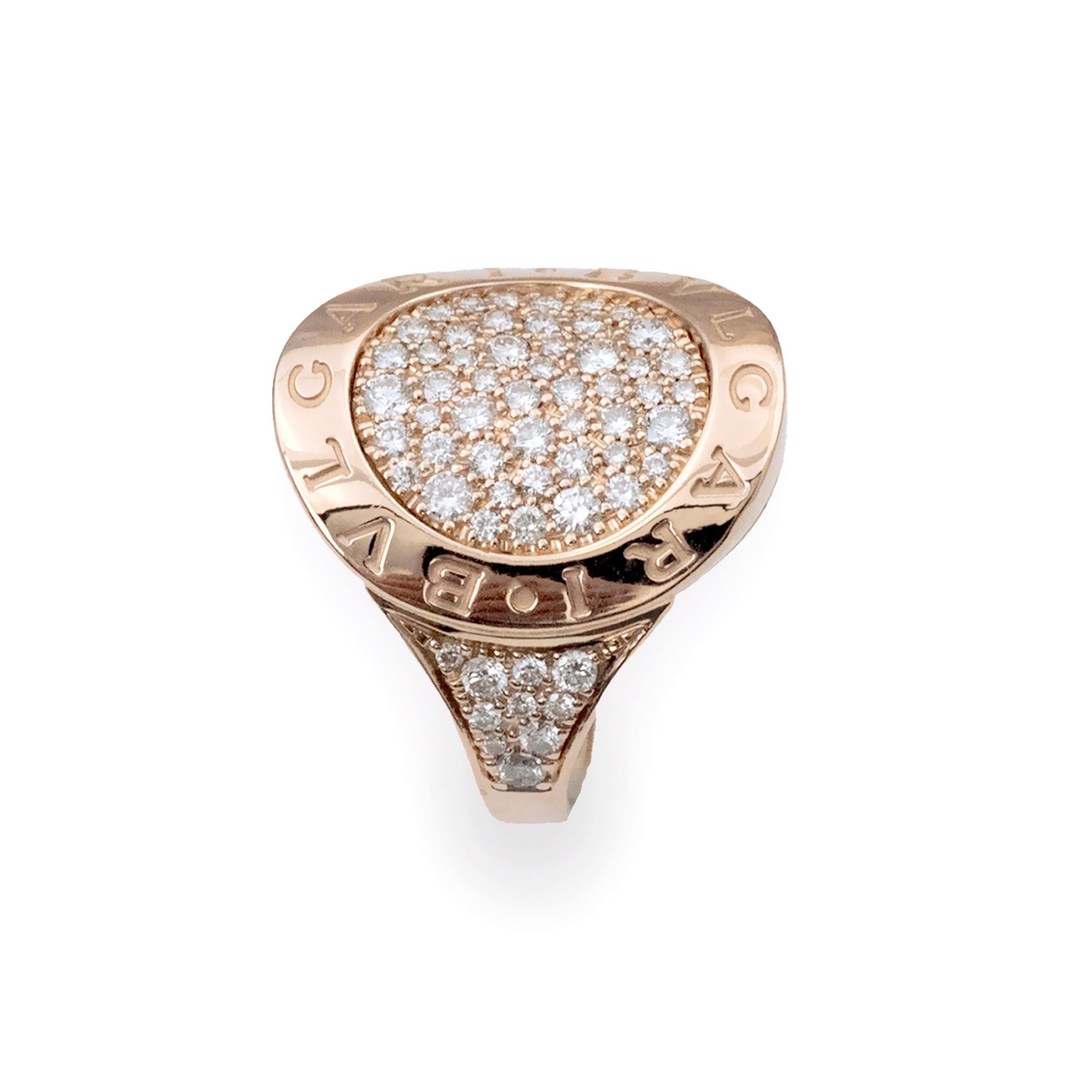 This Bvlgari Bvlgari ring in 18 karat rose gold showcases the iconic double-logo design inspired by ancient Roman inscriptions. The round bezel is engraved with the “BVLGARI • BVLGARI” signature and set with approximately 0.95 carat of brilliant-cut