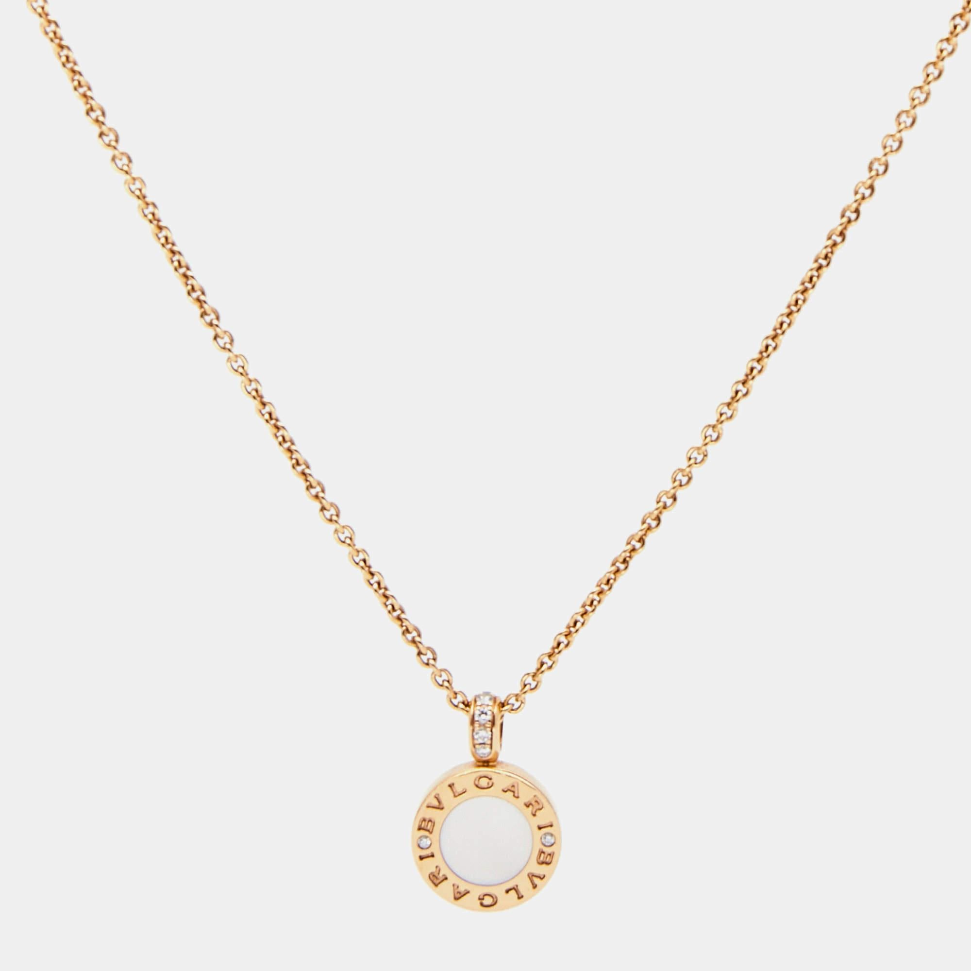 The Bvlgari Bvlgari necklace exudes luxury with its exquisite design. Crafted in 18k rose gold, it features a pendant showcasing a vibrant carnelian gemstone and a delicate mother of pearl, encircled by iconic Bvlgari branding. Dazzling diamonds