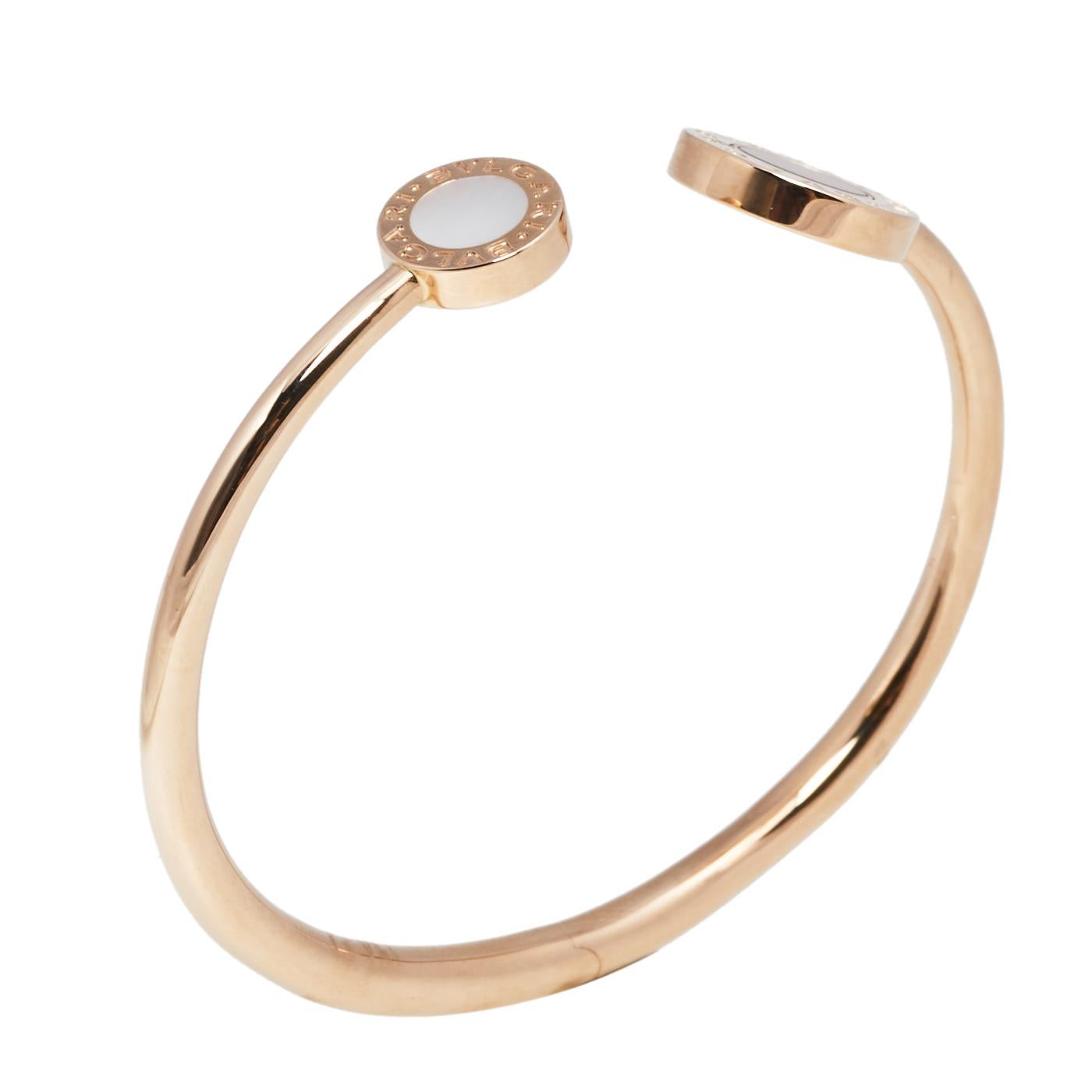 Elevate your look instantly with this Bvlgari bracelet. Crafted from 18k rose gold in a simple bangle style with an open cuff design, this piece carries two circular ends inlaid with mother of pearl and carnelian. Easy to wear and versatile in use,