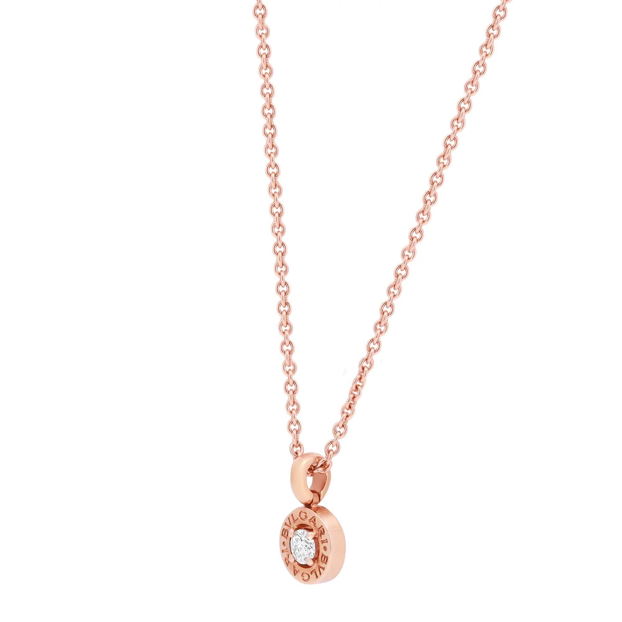 Minimalist yet classy, Bvlgari Bvlgari diamond pendant necklace. Crafted in fine 18K rose gold. This necklace features a center prong set round brilliant cut diamond encrusted in a round Bvlgari Bvlgari stamped pendant with an adjustable cuban link