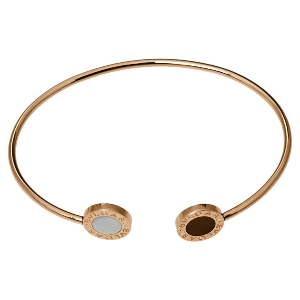 Elevate your look instantly with this stylish and trendy Bvlgari bracelet. Crafted from 18k rose gold in a simple bangle style with an open cuff design, this piece carries two circular ends engraved with 'Bvlgari Bvlgari' on the bezel and inlaid