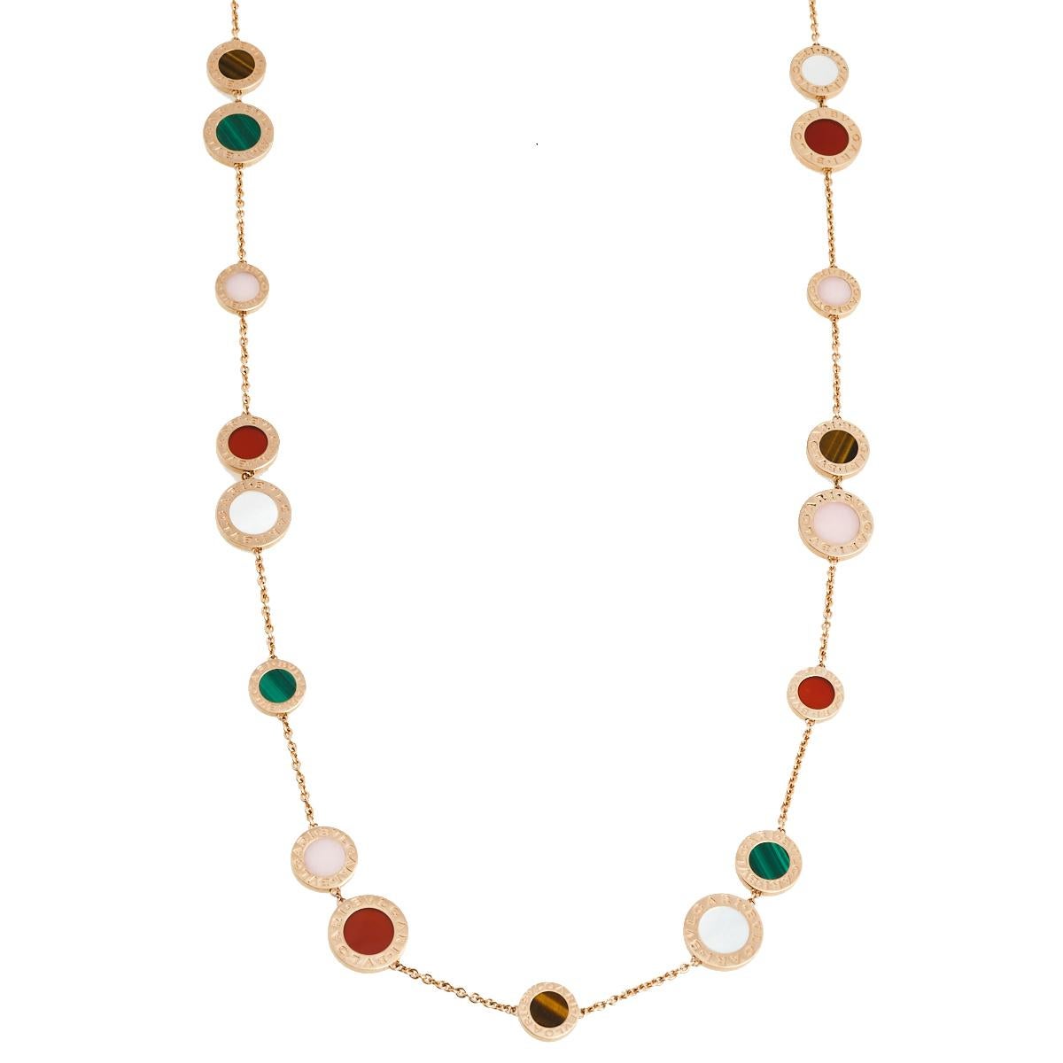 This Bvlgari necklace speaks beauty with its details. Crafted from 18k rose gold in a long silhouette, the necklace has multiple signature coin motifs inlaid with colorful gemstones like carnelian, malachite, mother of pearl, tiger's eye, and pink