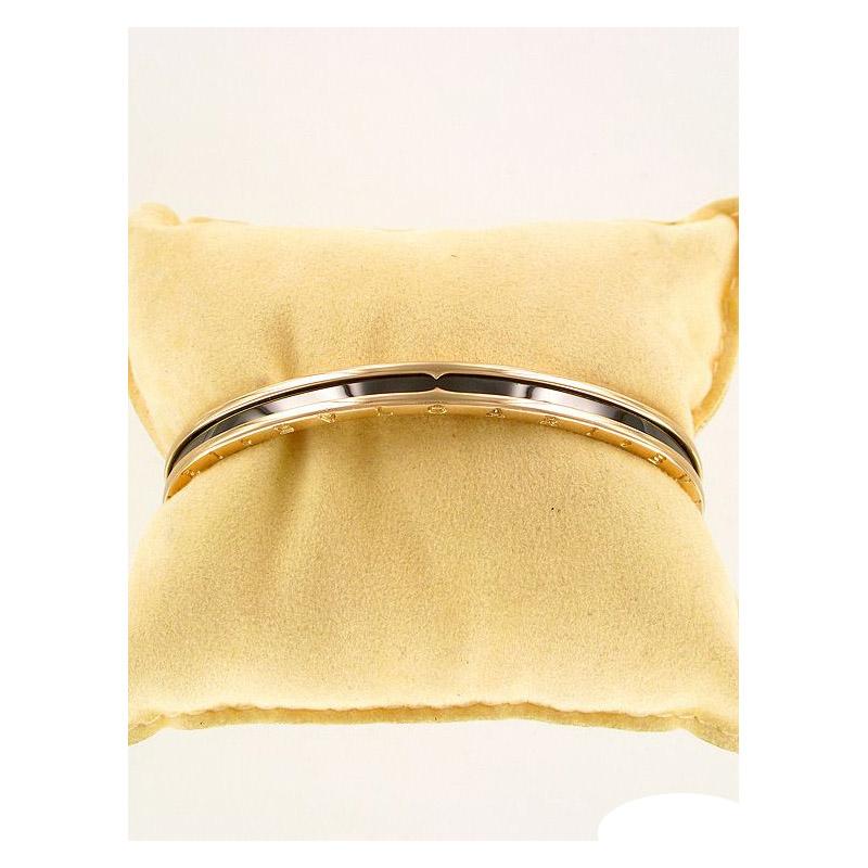 Bvlgari B.Zero 1 18K Rose Gold Steel Bracelet SZ6.5
Bulgari B.Zero1 Rose Gold & Black Ceramic Cuff Bangle

Description: This striking Bulgari B Zero 1 bangle in 18k rose gold is offset with a black strip of high polished carbon coated steel. It