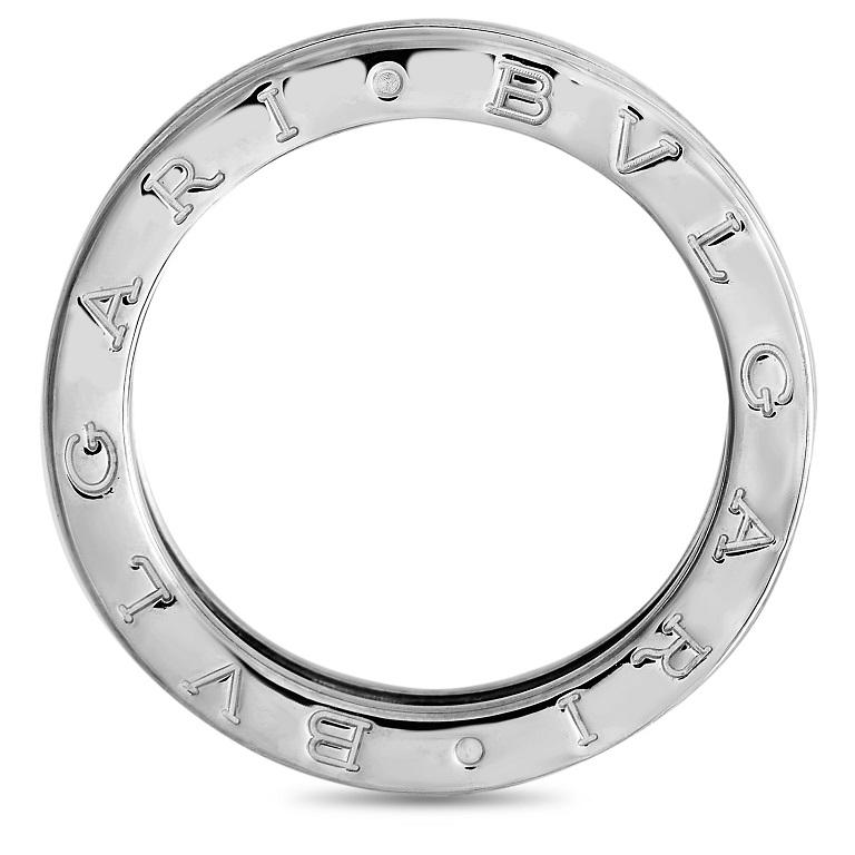This simple Bvlgari band ring from the, B.Zero1 collection, will never go out of style. The ring is made from 18k White Gold and features the Bvlgari brand name along the top and bottom edges of the ring. The ring has a band thickness of 5 mm and a