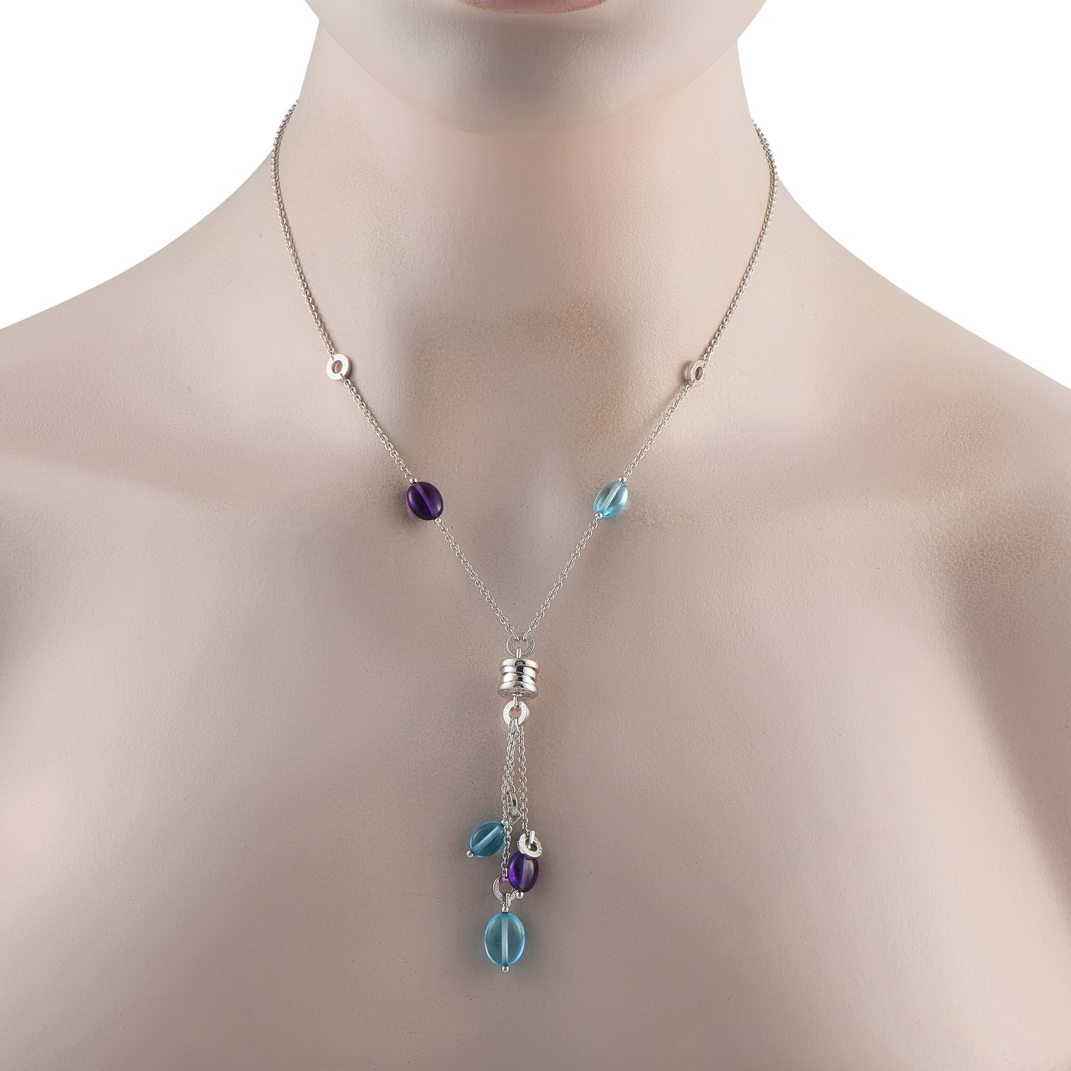Questa collana Bvlgari B.Zero1 in oro bianco 18 carati è un pezzo colorato, raffinato e decisamente indossabile. La catena da 16 è caratterizzata da gemme multicolori blu e viola e da accenti circolari con inciso il nome del marchio di lusso. Un