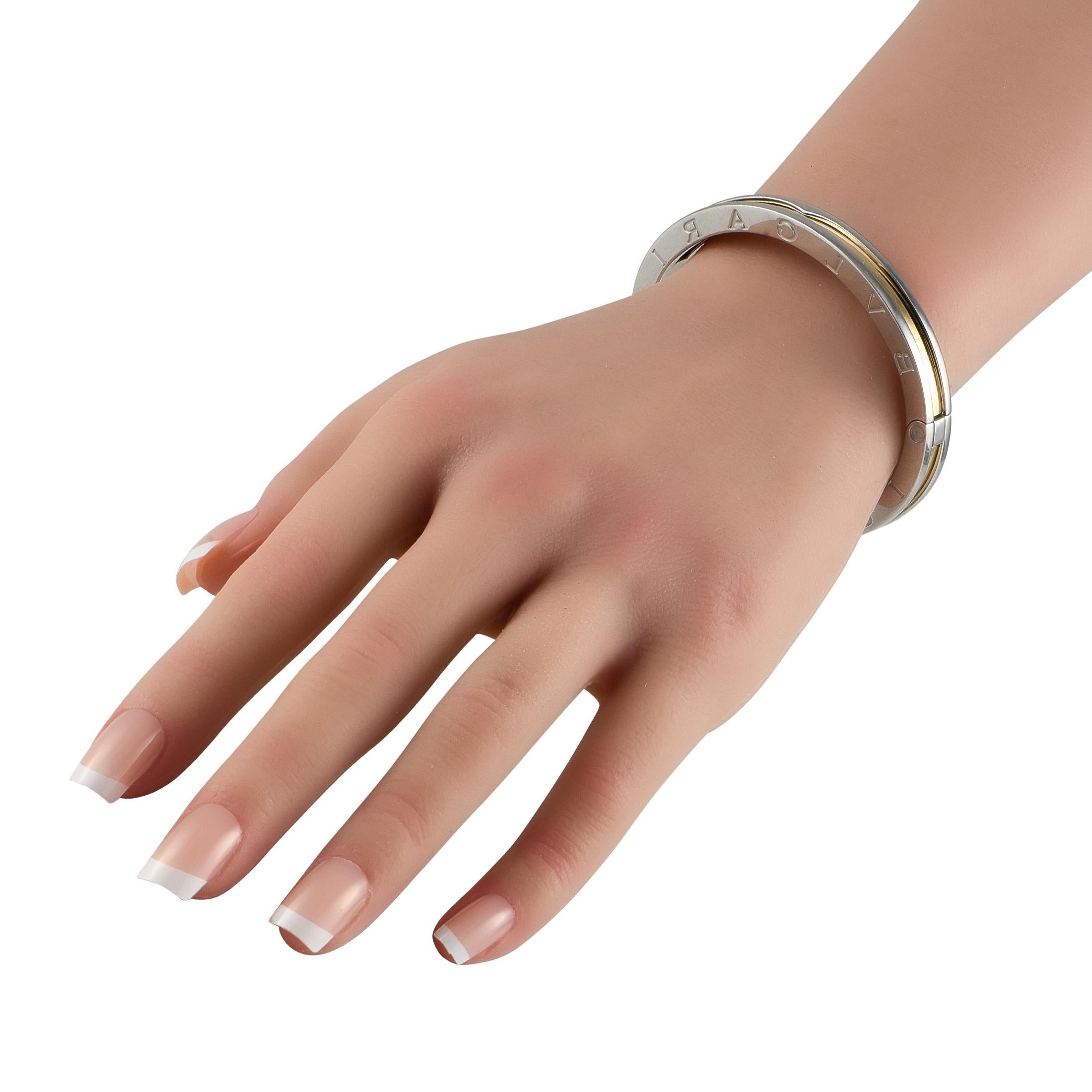 This two-toned Bvlgari B.Zero1 bracelet is impossible to ignore. Crafted from Stainless Steel, it beautifully showcases the luxury brands signature on the sides. An 18K Yellow Gold accent at the center of this bangle-style bracelet adds extra color