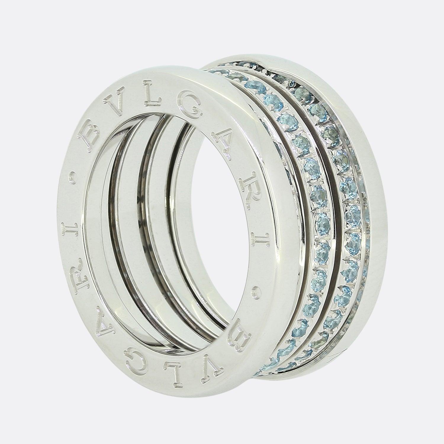 Il s'agit d'une bague B.Zero1 d'excellente facture de la maison de joaillerie italienne de renommée mondiale Bvlgari. Réalisée en or blanc 18 ct, elle présente des anneaux centraux sertis de topazes bleues entre une bordure en relief gravée des