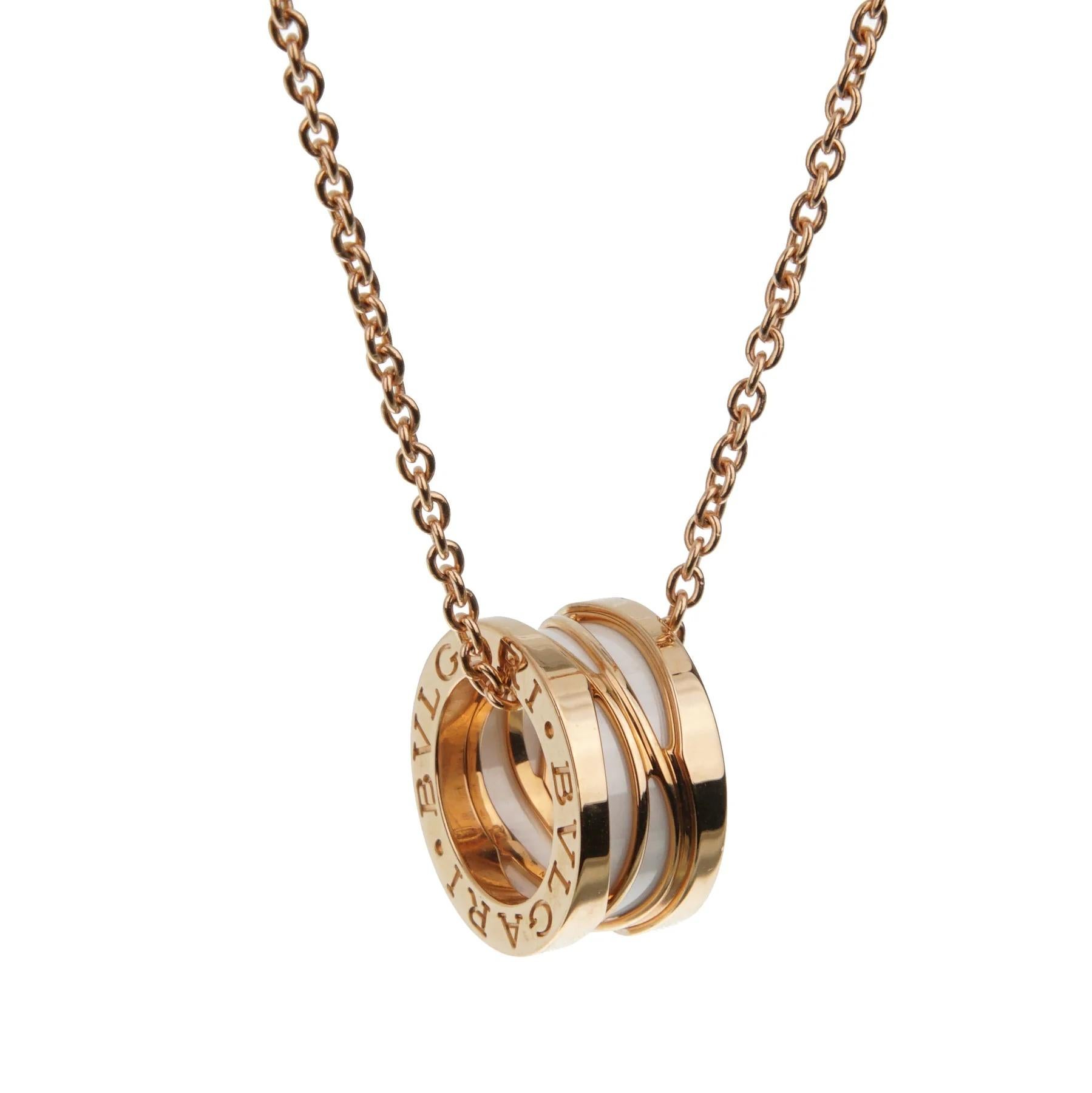 Le pendentif de ce collier exquis présente un mélange saisissant de matériaux et d'éléments de conception. Au centre de la suspension se trouve une bande lisse et brillante de céramique blanche, qui ajoute une touche contemporaine à la pièce. Ce