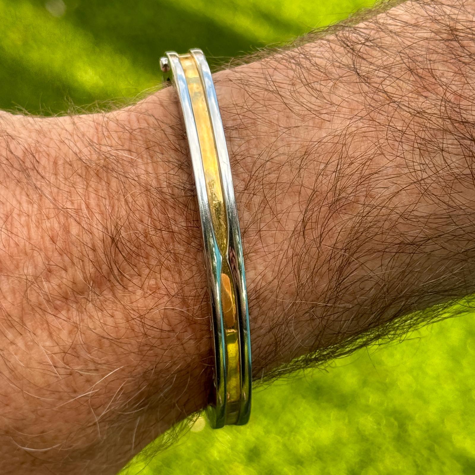 Il bracciale bangle con cerniera Bvlgari B.zero1 è un pezzo audace e sofisticato, realizzato in acciaio inossidabile e oro giallo 18 carati. Con una larghezza di 7 mm, questo design elegante incarna la miscela di eleganza moderna e artigianalità