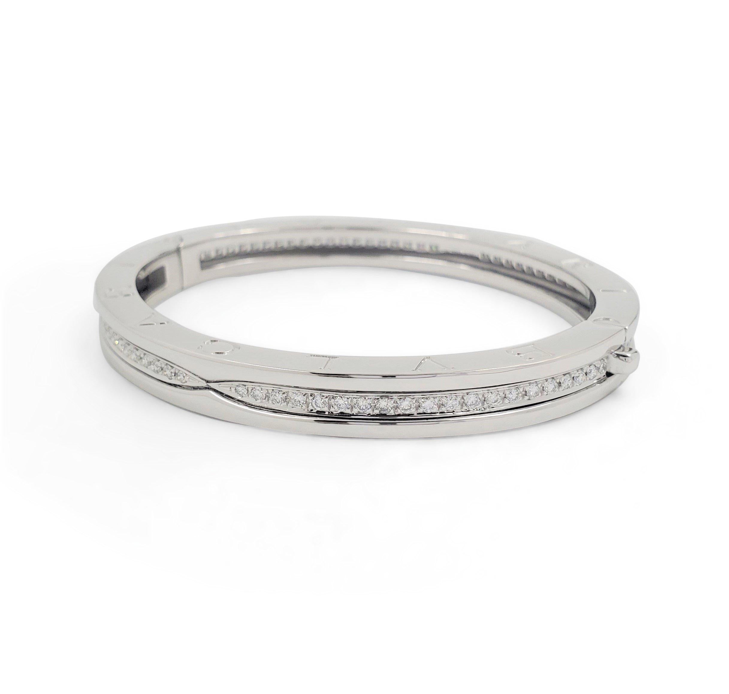 Authentic Bvlgari 'B.Zero1' bracelet crafted in 18 karat white gold engraved with the Bvlgari logo on both sides. The bracelet has a high polished lip of gold on either side and a center strip pave set with approximately 84 round brilliant cut