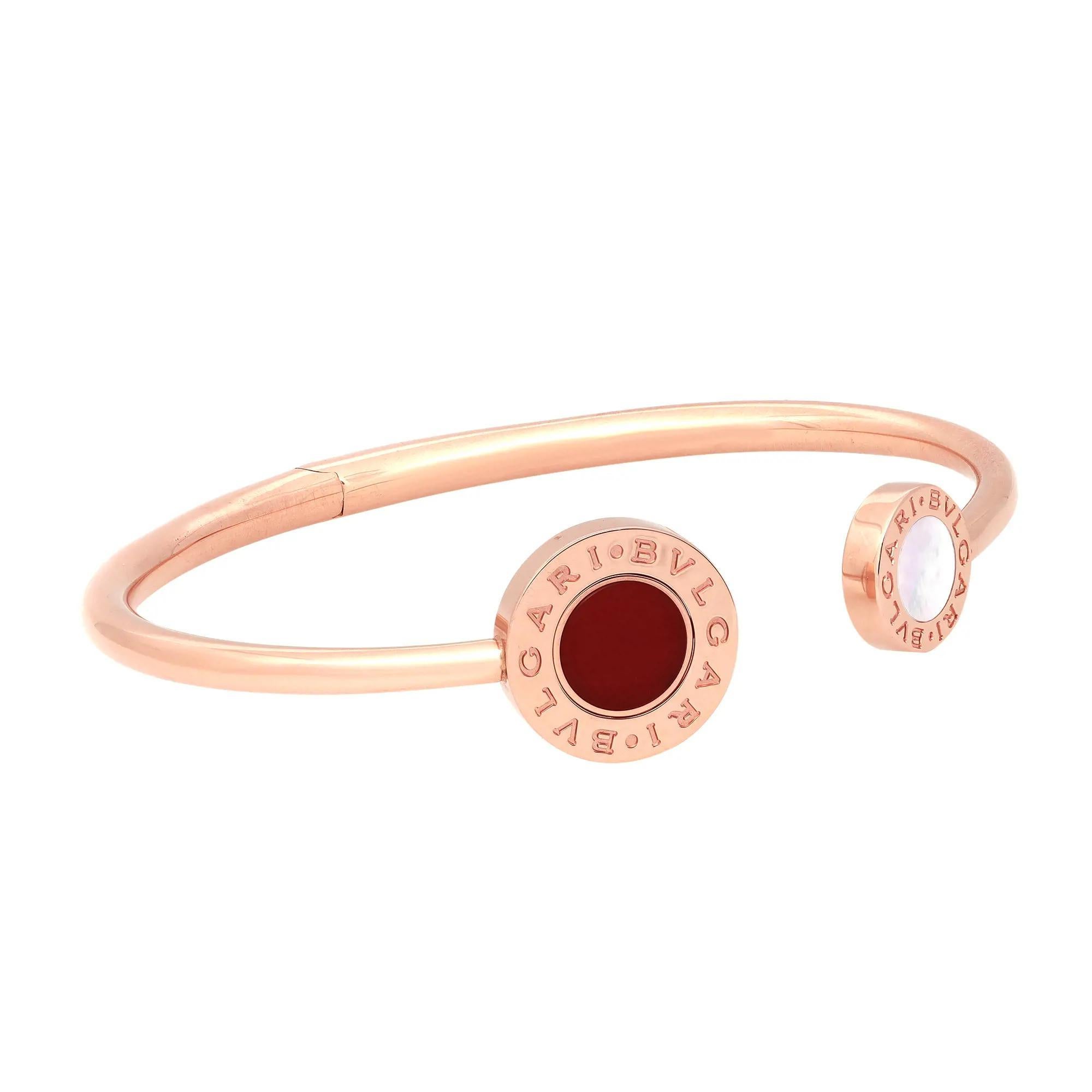 De la collection Bvlgari Classic. Fusion élégante de la culture et de la modernité, ce bracelet chic à charnière comporte un double logo gravé, serti de nacre et d'une cornaline, créant ainsi deux options de couleurs différentes en un seul bijou.