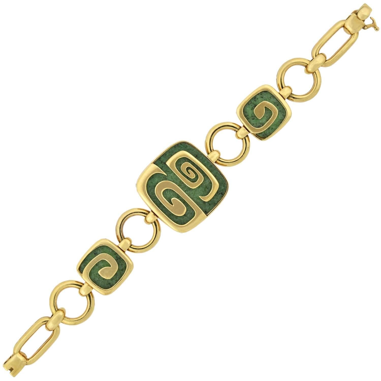 A fabulous Estate garnet link bracelet from the Bvlgari Theme Collection! This limited edition bracelet is crafted in 18kt yellow gold and adorns three gorgeous green hydrogrossular garnet links. The largest of the square shaped links rests at the