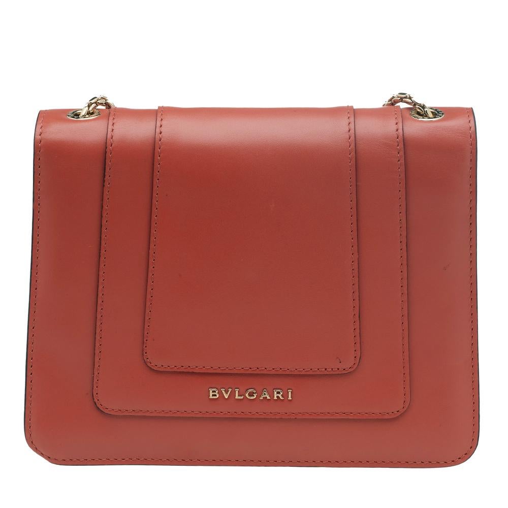Dazzle the eyes that fall on you when you swing this stunning Bvlgari creation. Crafted from leather in a breathtaking coral pink hue, the shoulder bag is styled with a flap that has the iconic Serpenti head closure. The bag has a spacious fabric