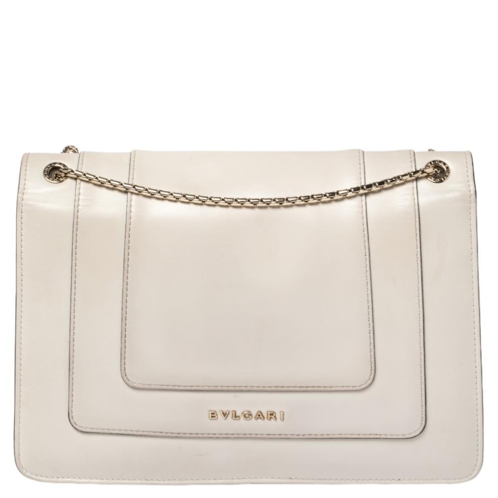 Add a dazzling element to your style with this stunning Bvlgari creation. Crafted from leather in a cream hue, the shoulder bag is styled with a flap that has the iconic Serpenti head closure. The bag has a fabric interior and a gorgeous gold-tone