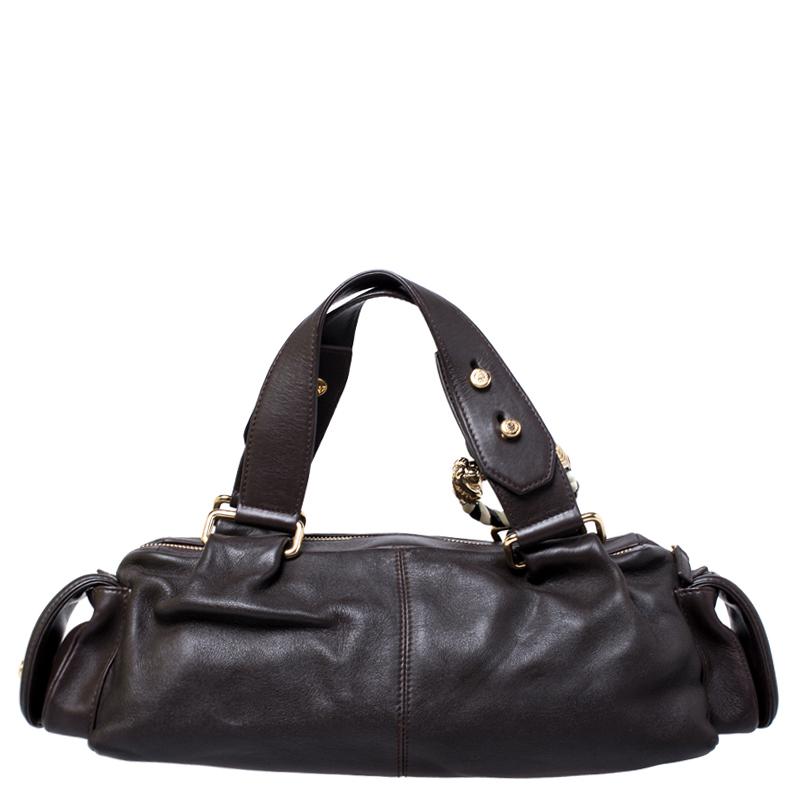 Coming from the house of Bvlgari, this stylish satchel is ideal for everyday wear. Crafted from dark brown leather, it features a lovely silhouette. It is equipped with two handles attached to the bag with gold-tone links and the front handle