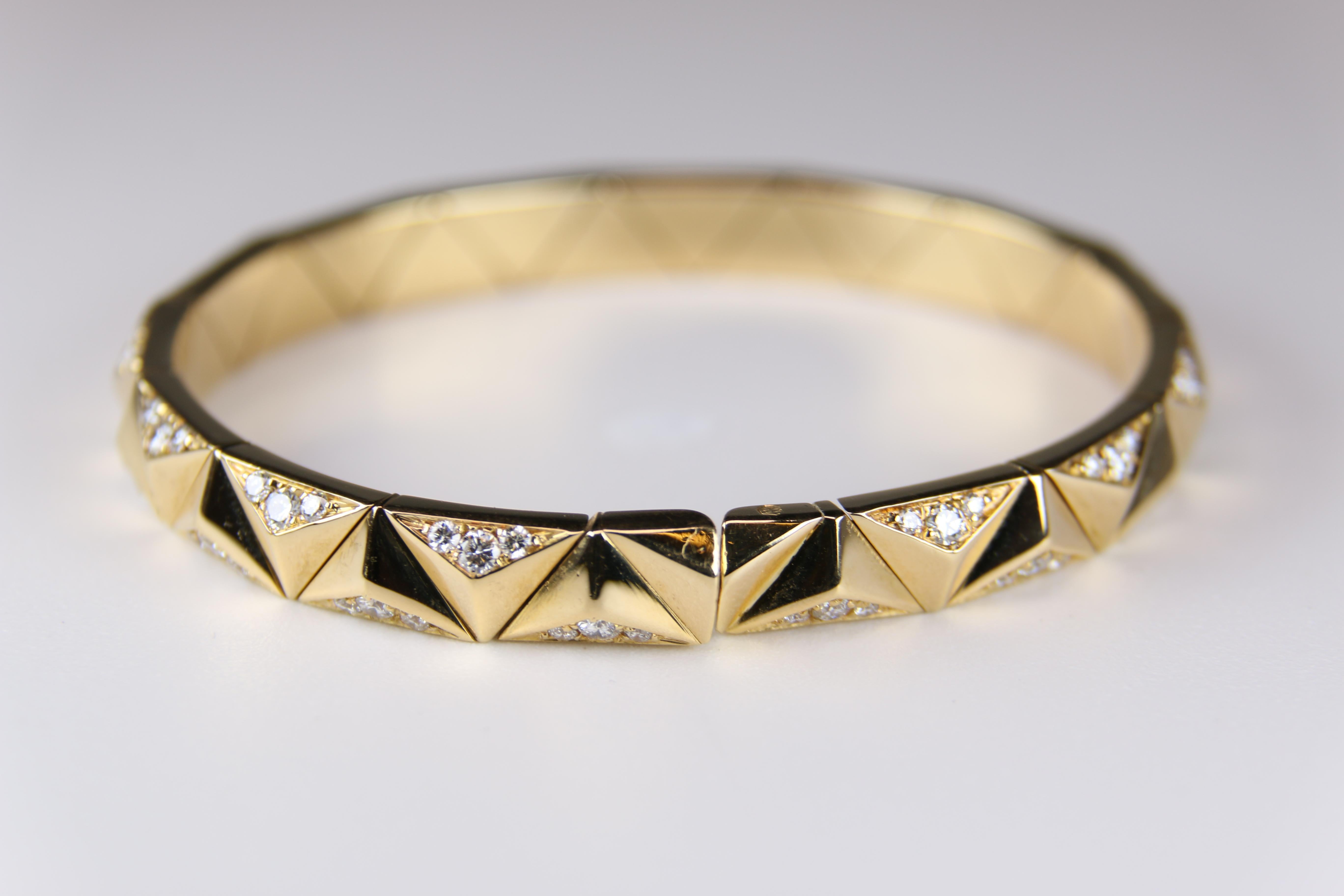 This Bulgari Designer 18K Yellow Gold and Diamond Flexible Cuff Bracelet has a serpentine zig/zag pattern with triangular links which are alternately pave set with round brilliant cut diamonds having an estimated 0.85 carat of total diamond weight. 