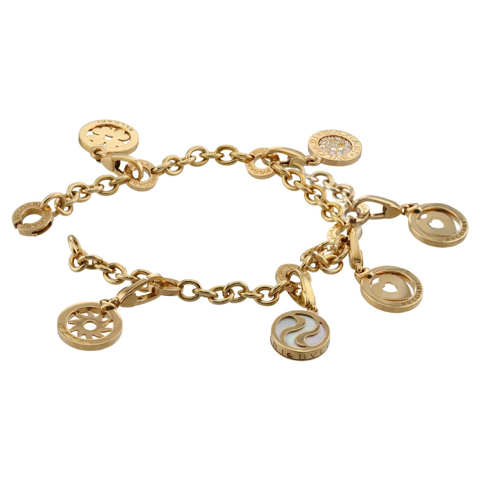 Ce magnifique bracelet Bvlgari est réalisé en or jaune 18 et comporte 5 charms ronds, à savoir un cœur, un trèfle, un soleil, un cercle en nacre et un pavé E-F-G.        Cercle de diamants VVS1-VVS2. Chaque charme porte l'inscription du logo