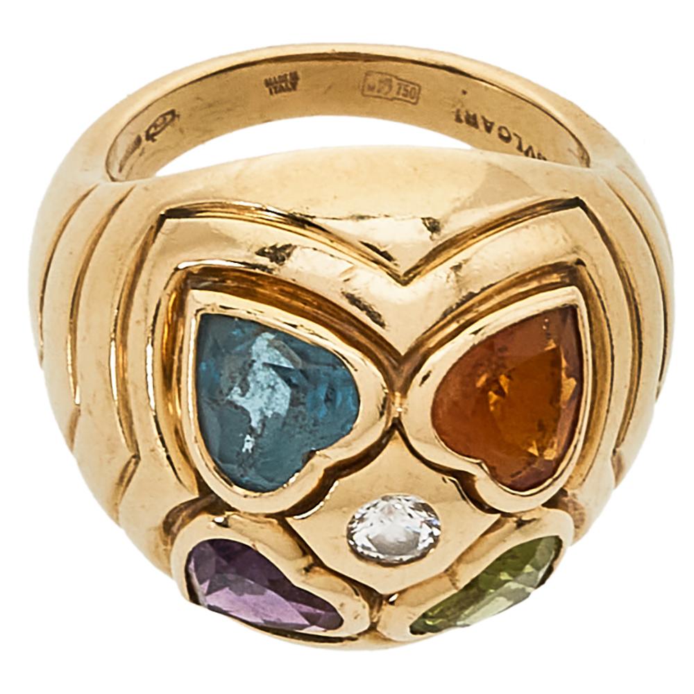 It is definitely love at first sight with this Bvlgari ring. Beautifully crafted from 18k yellow gold, it comes designed in a dome shape. The head of the ring flaunts an assembly of heart motifs inlaid with colorful gemstones and a sparkling diamond