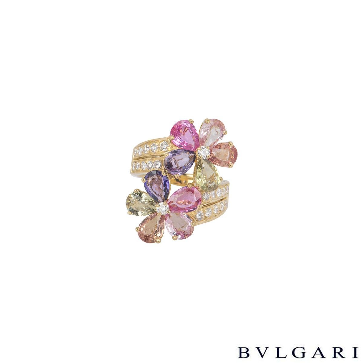 A beautiful 18k yellow gold, diamond and sapphire ring by Bvlgari from the Sapphire Flower collection. The ring comprises of 2 flower motifs composed of 10 fancy coloured pear cut sapphires as petals with 20 round brilliant cut diamonds in a pave