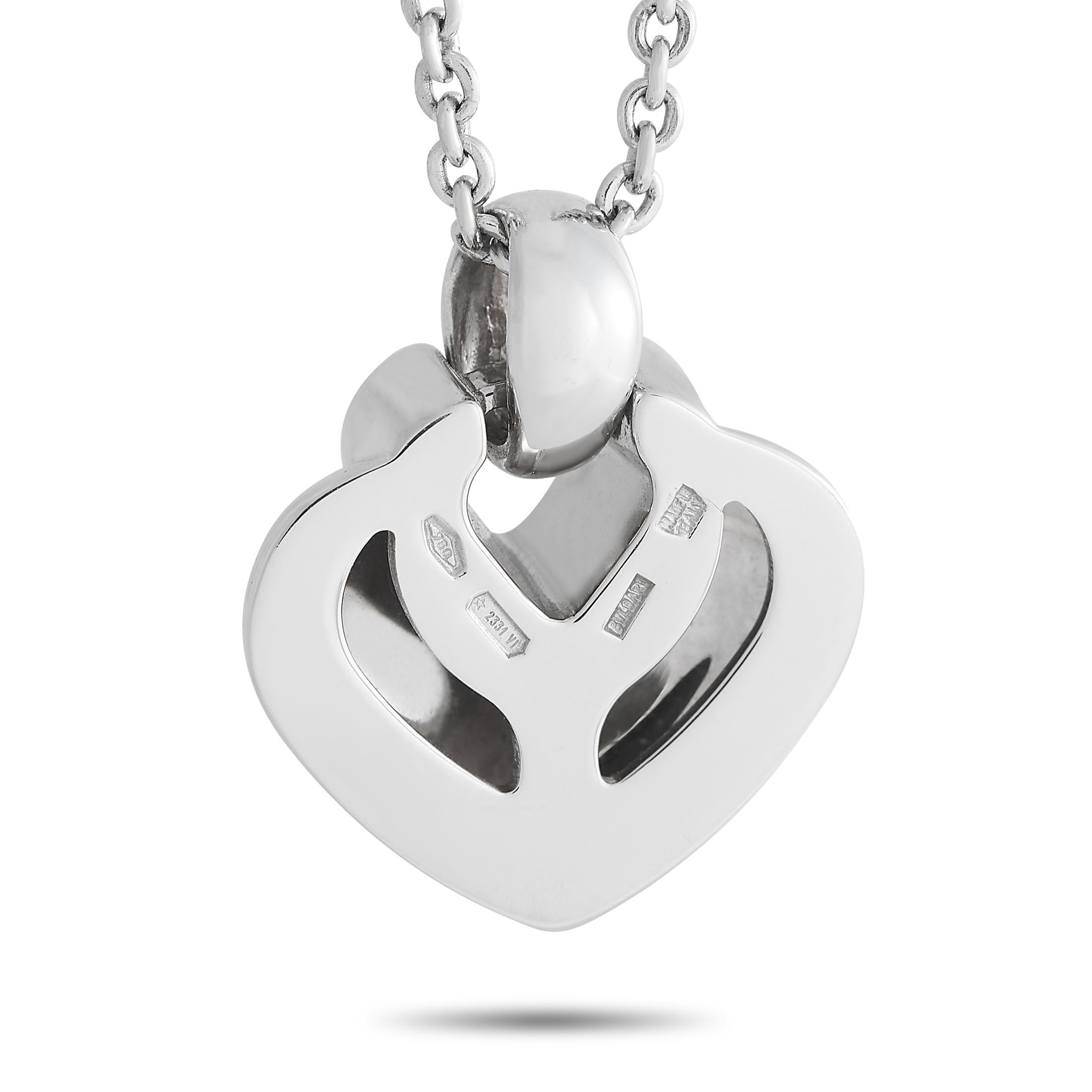 This charming diamond heart necklace from the Doppio Cuore collection of Bvlgari is unexpectedly flattering. It features a polished white gold pendant measuring approximately 0.65 in diameter. Round diamonds trace the inner heart outline near the
