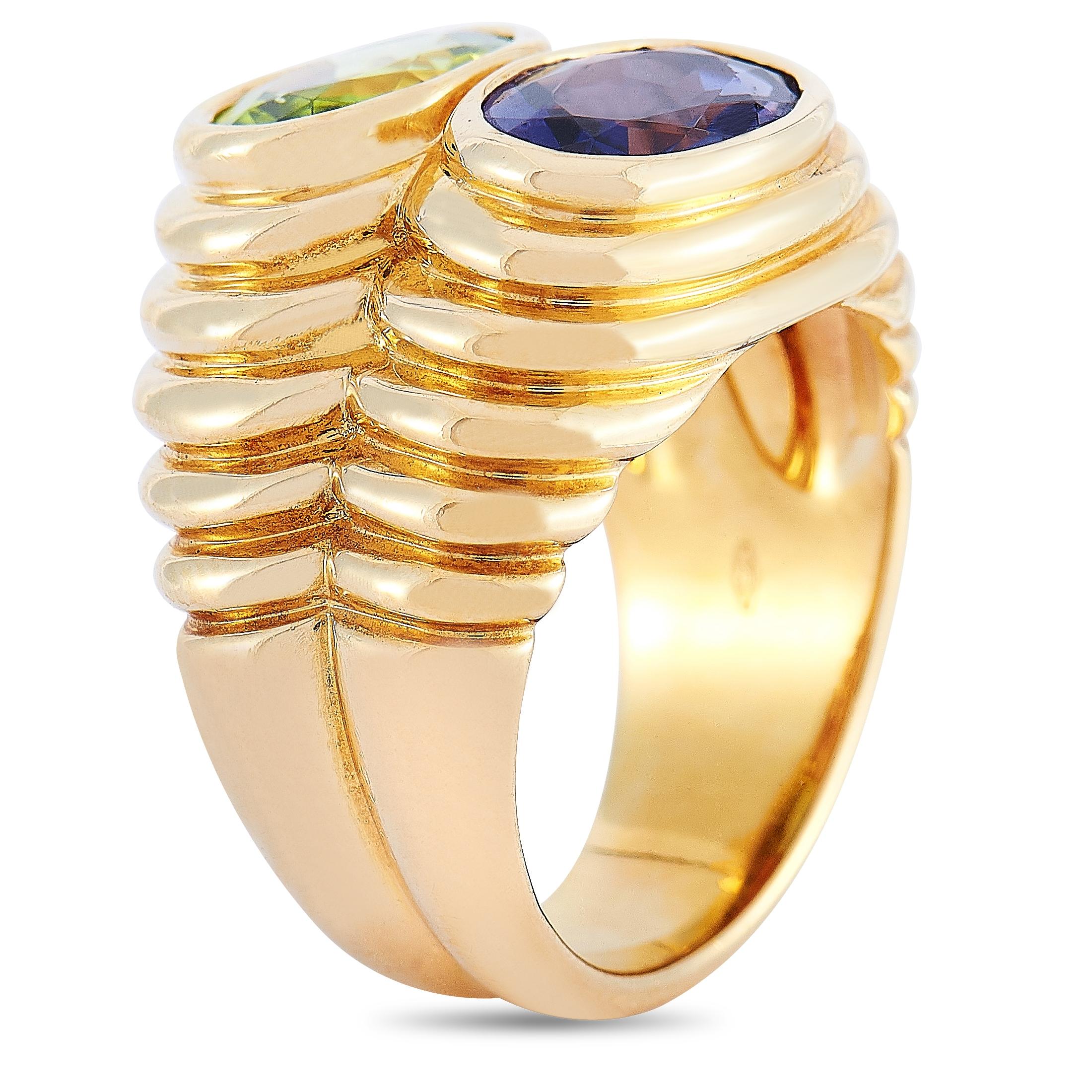 The Bvlgari “Doppio” ring is made of 18K yellow gold and embellished with a peridot and an iolite. The ring weighs 13.9 grams and boasts band thickness of 5 mm and top height of 6 mm, while top dimensions measure 10 by 15 mm.
 
 This jewelry piece