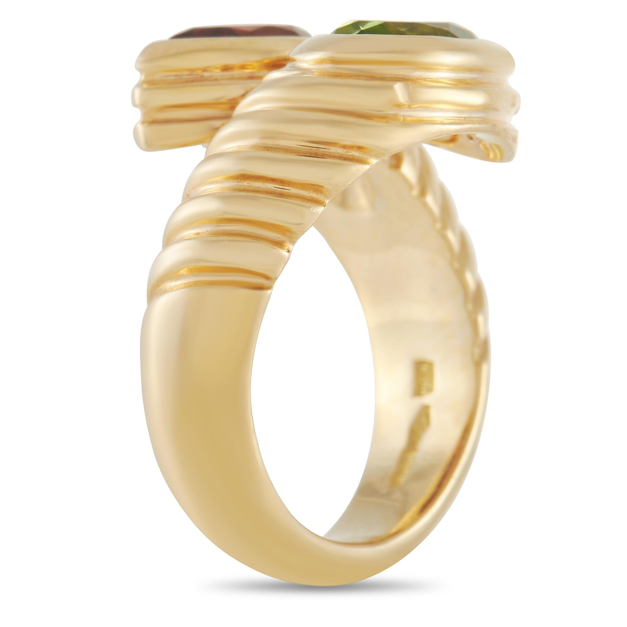 A Bvlgari ring from the 80s, this Doppio Gem-Set Ring in yellow gold is a statement-making accessory that is worthy of a spot in your collection. The bypass shank with textured detail features two faceted gems on each end. One is a green peridot and