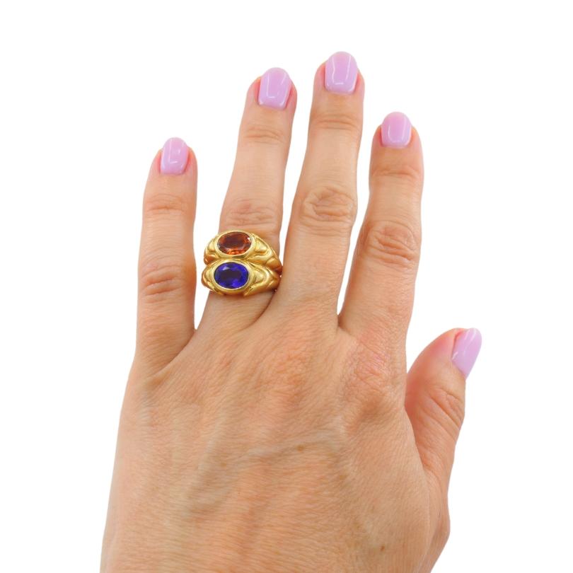 
This exquisite Bvlgari Doppio Ring made from 18k yellow gold, the piece features a stunning combination of oval-cut amethyst and citrine gemstones, elegantly set in a bezel setting at the top. The vibrant purple of the amethyst and the warm orange