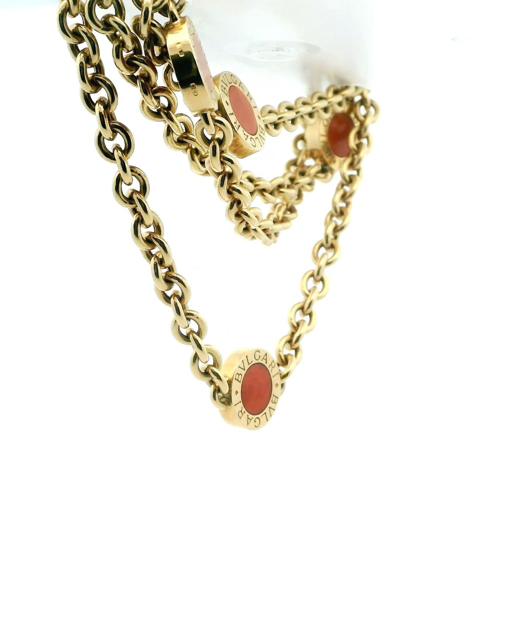 Elegante Bvlgari 18k Gold Korallenkette. Dieses exquisite Stück ist aus 18 Karat Gold gefertigt. Die Halskette besteht aus runden, orangefarbenen Korallensteinen, die jeweils in die Goldglieder eingefasst sind. Das Design ist ein Zeugnis