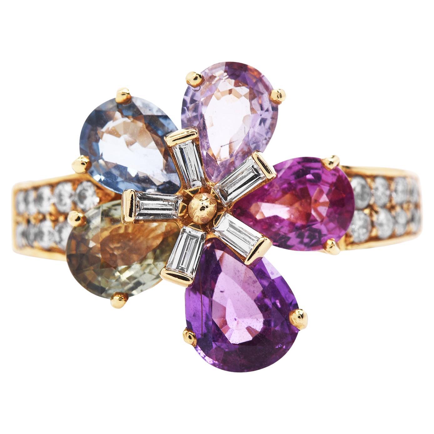 These chic designer Bvlgari multi-color sapphire and diamond ring is crafted in solid 18-karat yellow gold, weighing 7.5 grams and measuring 16mm x 7mm high. They are composed of 5 natural, pear-shaped brilliant-cut sapphires, simulating flower