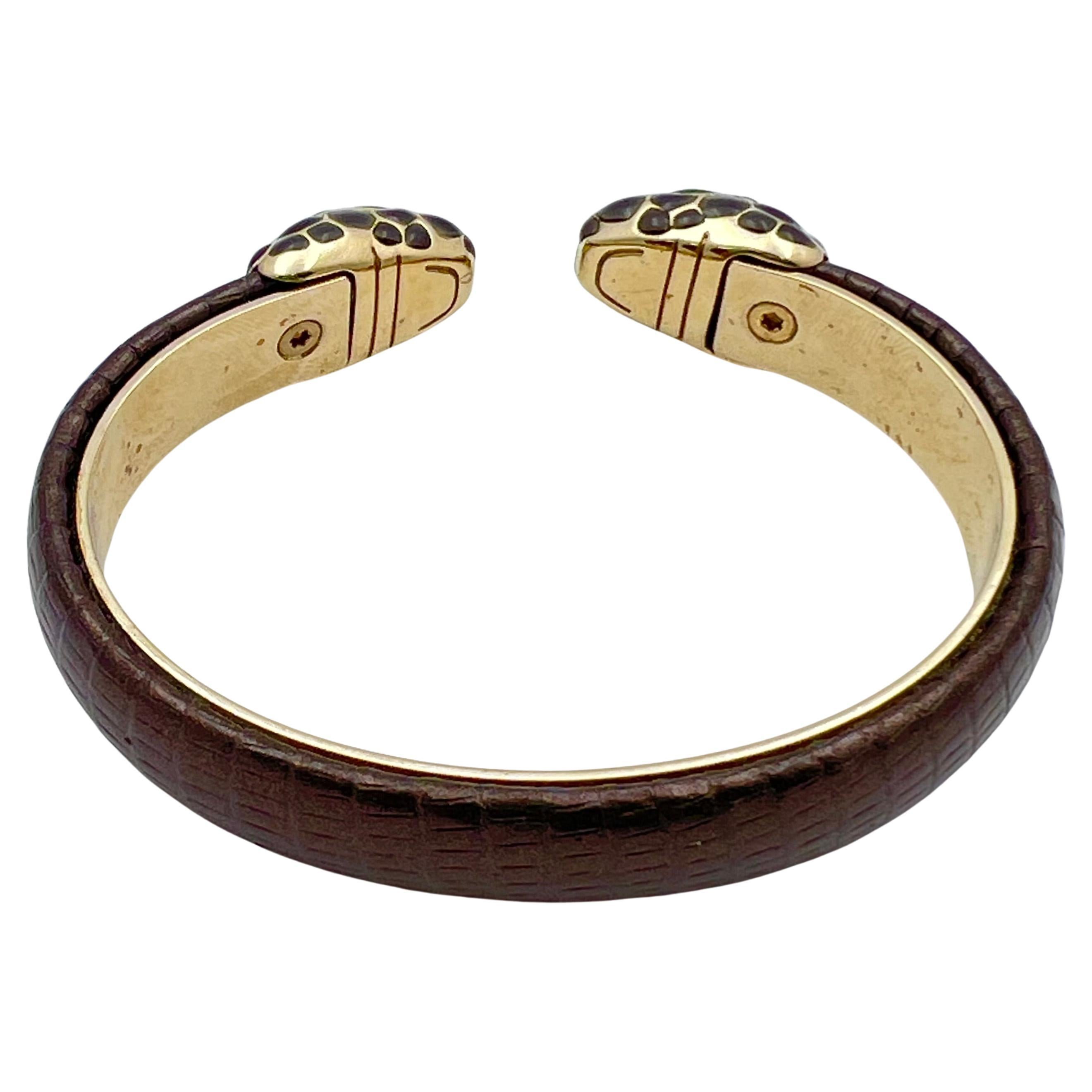 Bracciale Forever in ottone placcato oro chiaro con inserti in argento.  Il motivo della testa di serpente è decorato con smalto grigio e crema e occhi in smalto verde.  Superficie in pelle karung di colore bronzo. Firmato 'BVLGARI' 'Made In Italy'.