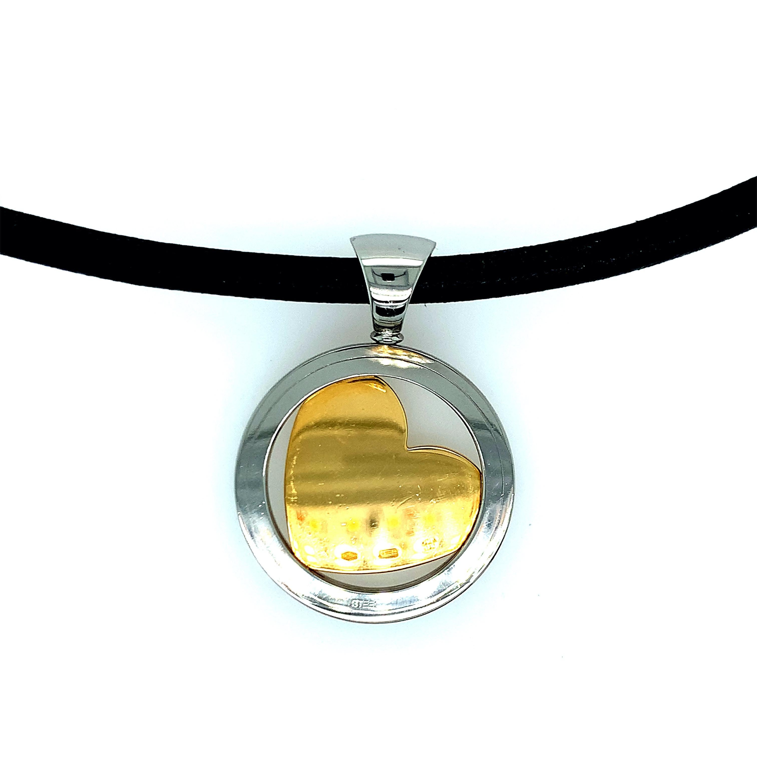 Created by Bvlgari, this necklace features a gold heart inside a circular steel. Diamonds in the shape of another heart is found within the gold heart. Total weight: 29.4 grams. Length of necklace: 17 inches. Pendant measurements: length 1.75 inch,