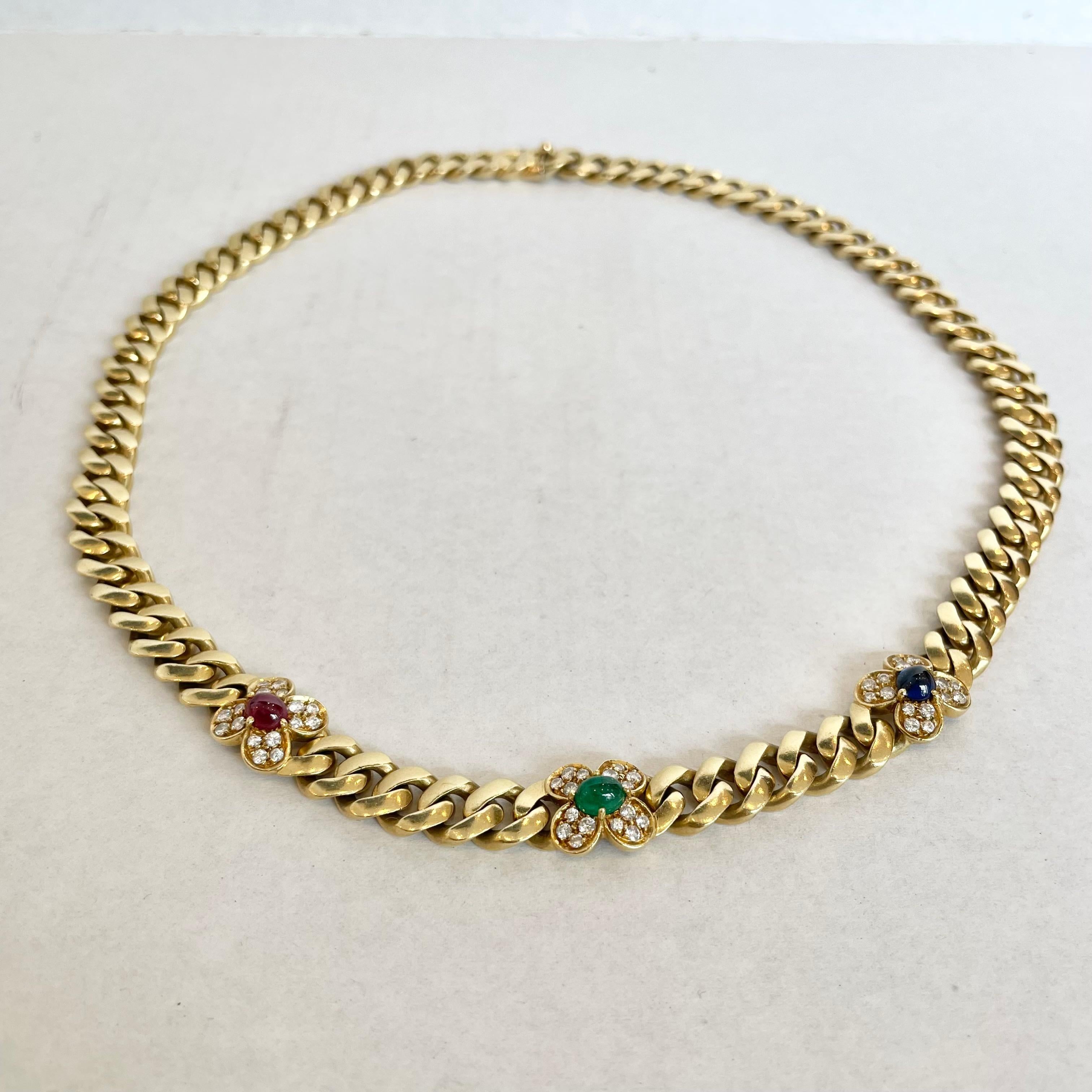 Stunning Bulgari necklace with a curb link chain embellished with three quatrefoil motifs set with sapphire, emerald, and ruby cabochons and accented by round diamonds. Italian assay and registry marks and signed Bulgari. Diamonds weighing a total