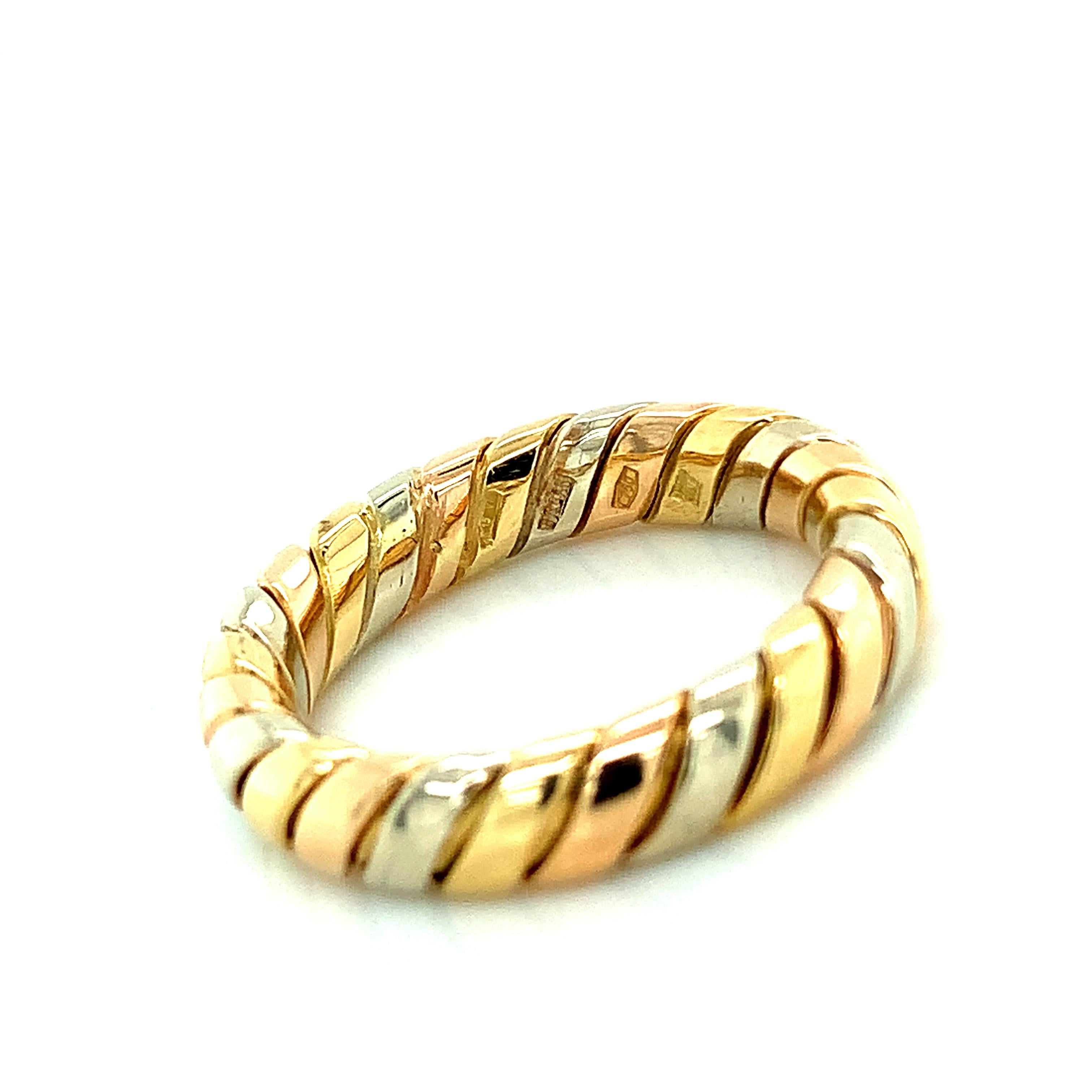 Bvlgari 18 karat yellow, white, and rose gold ring from the iconic Tubogas collection. Marked: Bvlgari / Made in Italy. It weighs 5.8 grams. Size 6.