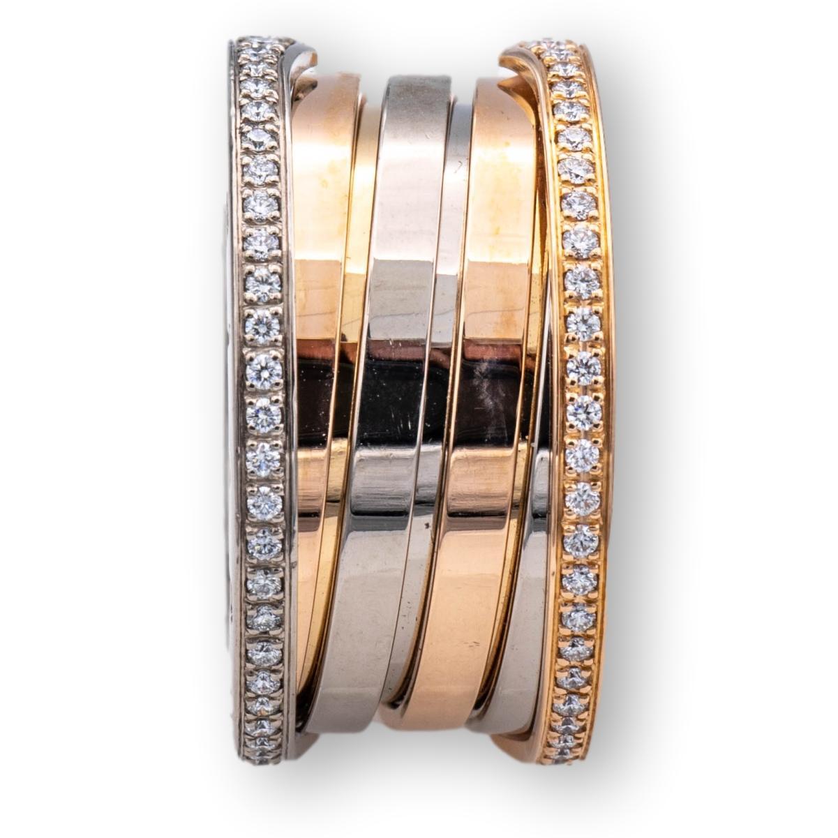 Bvlgari B-Zero band ring from the Labyrinth collection finely crafted in 18 karat rose and white gold studded with 2 rows of bead set round brilliant cut diamonds at each edge weighing 0.57 carats total weight approximately. 
All hallmarks are
