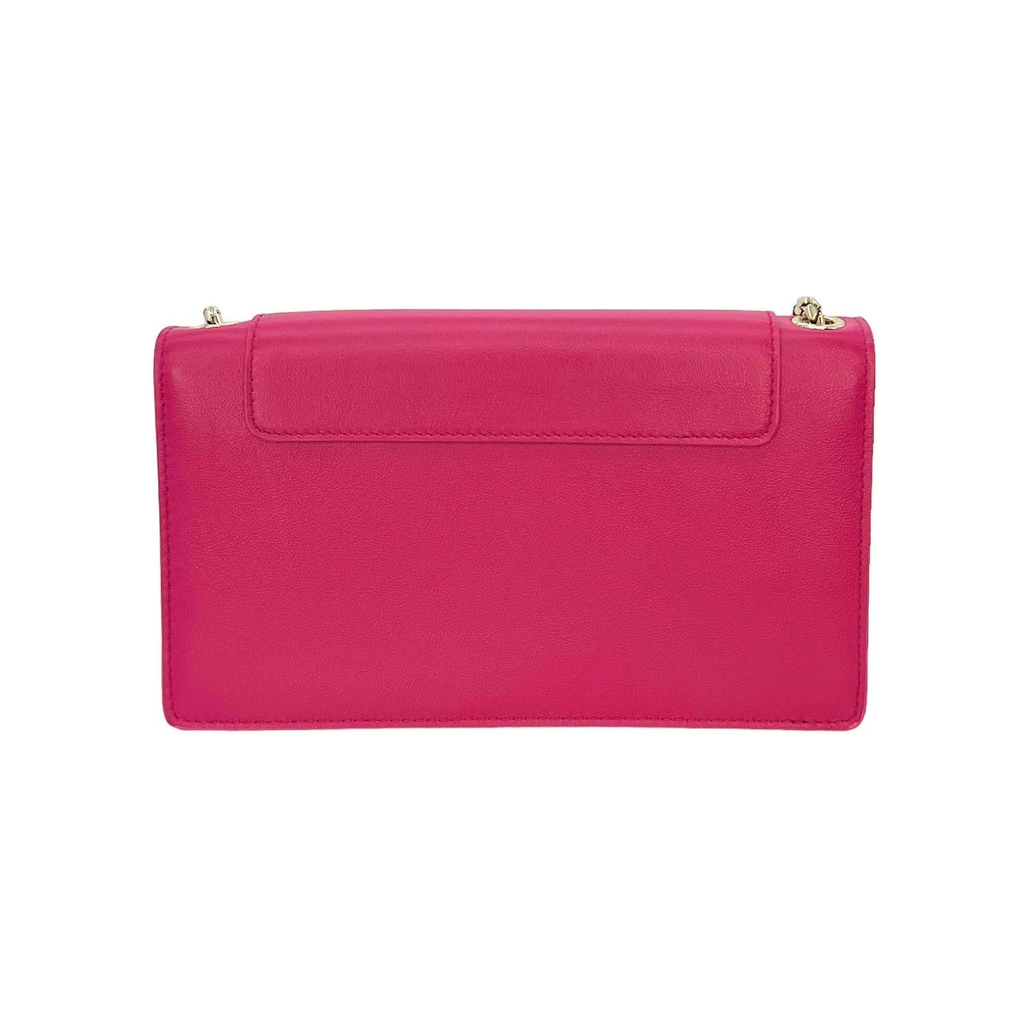 This Bvlgari Crossbody Bag was made in Italy and it is finely crafted of a pink leather exterior with gold-tone hardware features. It has a long chain-link shoulder strap. It has a fold over magnetic snap closure that opens up to a pink leather