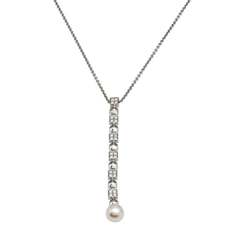 Absolutely wearable and timeless. This wondrous thing of beauty is made from 18k white gold and the chain holds a long pendant detailed with diamonds and a cultured pearl. From the marriage of the stones with the gold to the overall simplistic
