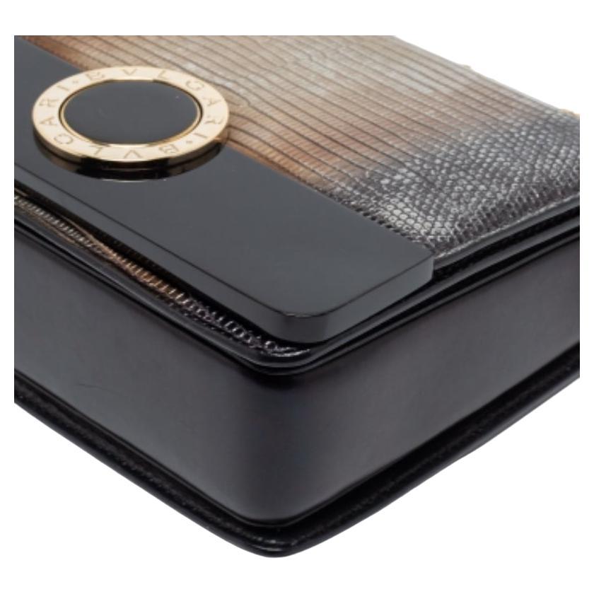 Ce superbe sac Bvlgari ajoutera une élégance luxueuse à votre style. Parfaitement conçu en lézard, cuir et Perspex, il est doté d'une longue bandoulière et d'un intérieur doublé de cuir pelucheux. La fermeture à rabat marquée sur le devant ajoute du