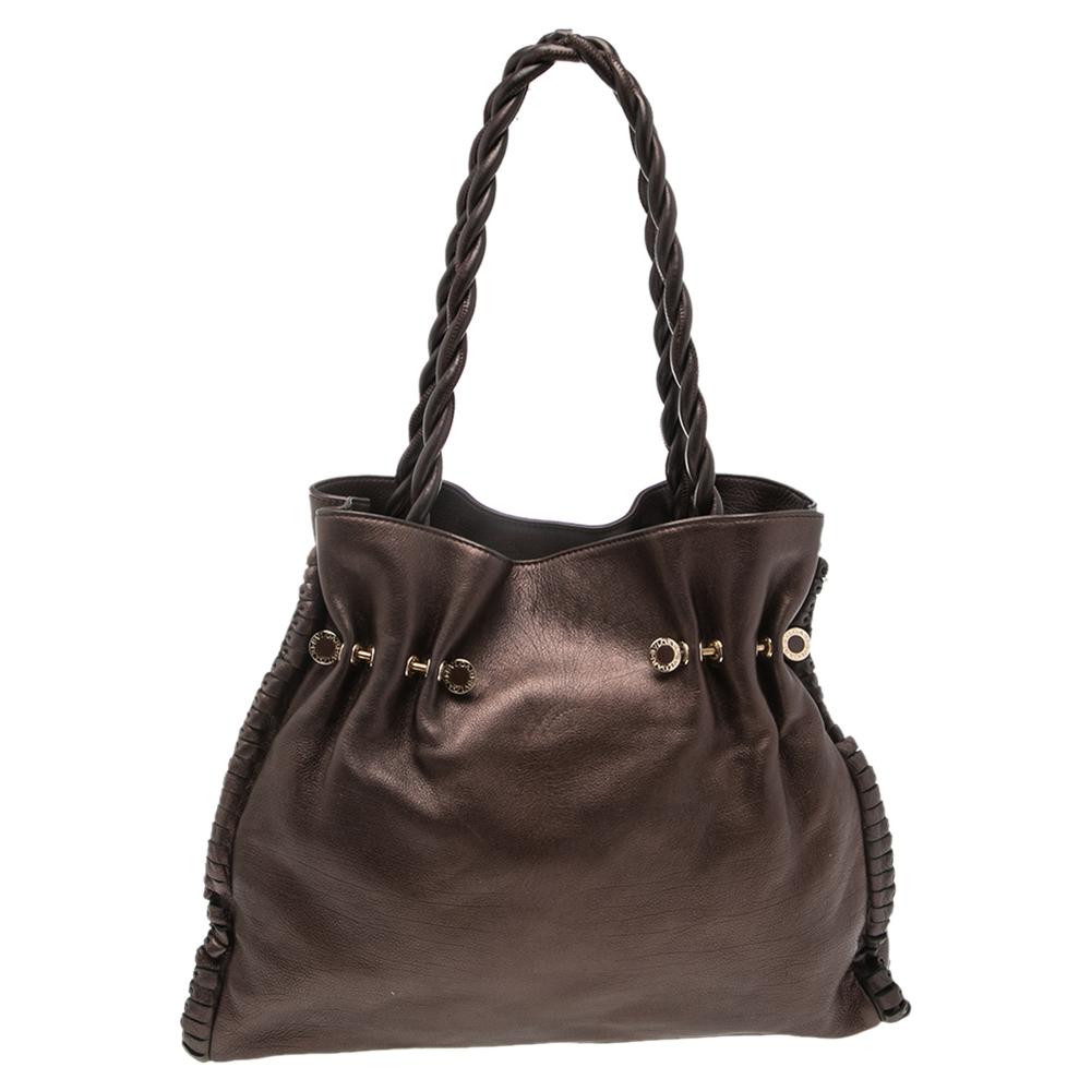 This Twistino Tina shopper tote from Bvlgari is a fabulous piece. The tote has been crafted from leather in a gorgeous metallic brown shade and equipped with two braided handles and gold-tone metal accents. The spacious interior comes with a pocket.