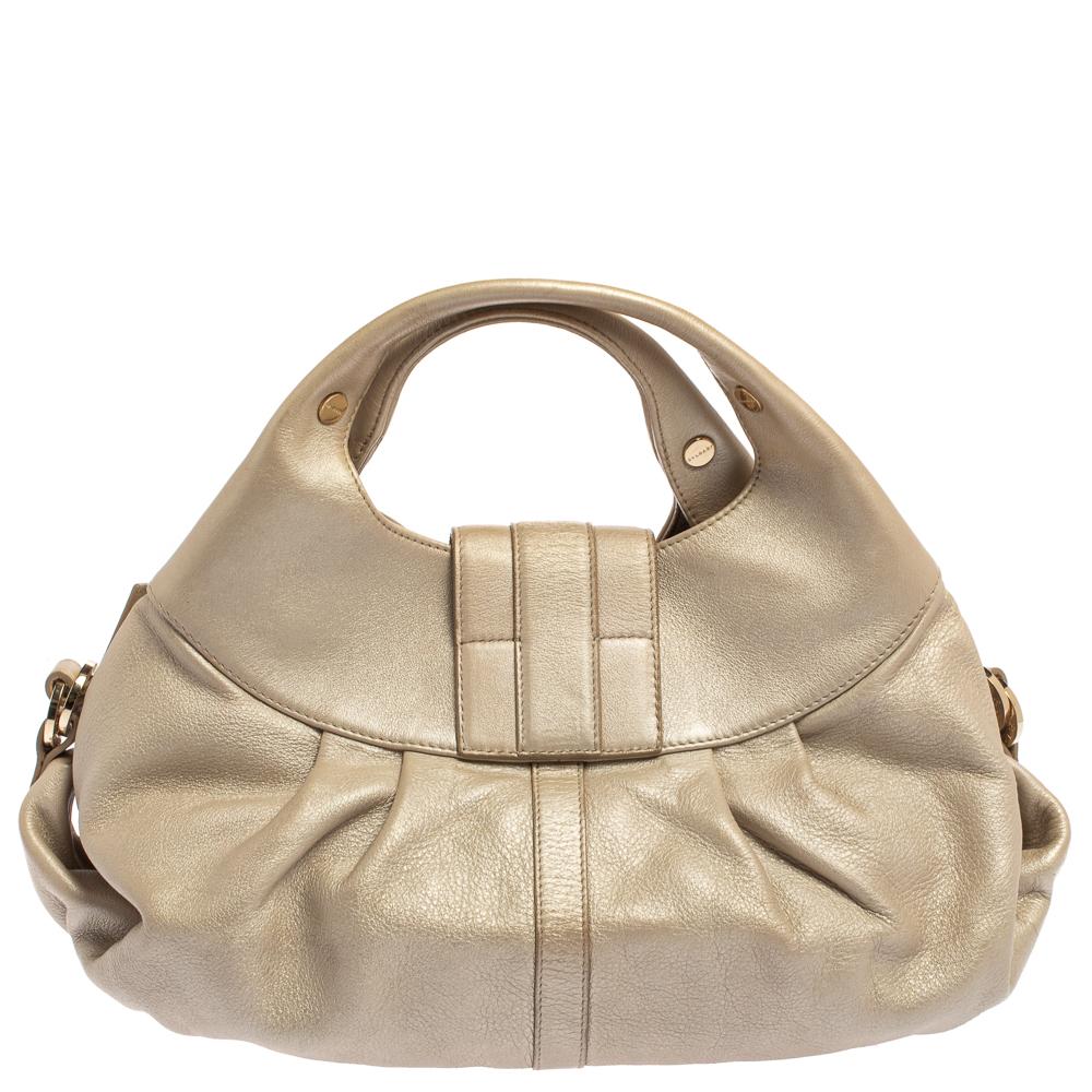 A known style from the house of Bvlgari, Chandra is loved for its comfortable silhouette and elegant appeal. This metallic gold one is meticulously crafted from leather and has the signature slouchy shape with broad pleats, dual top handles, and a