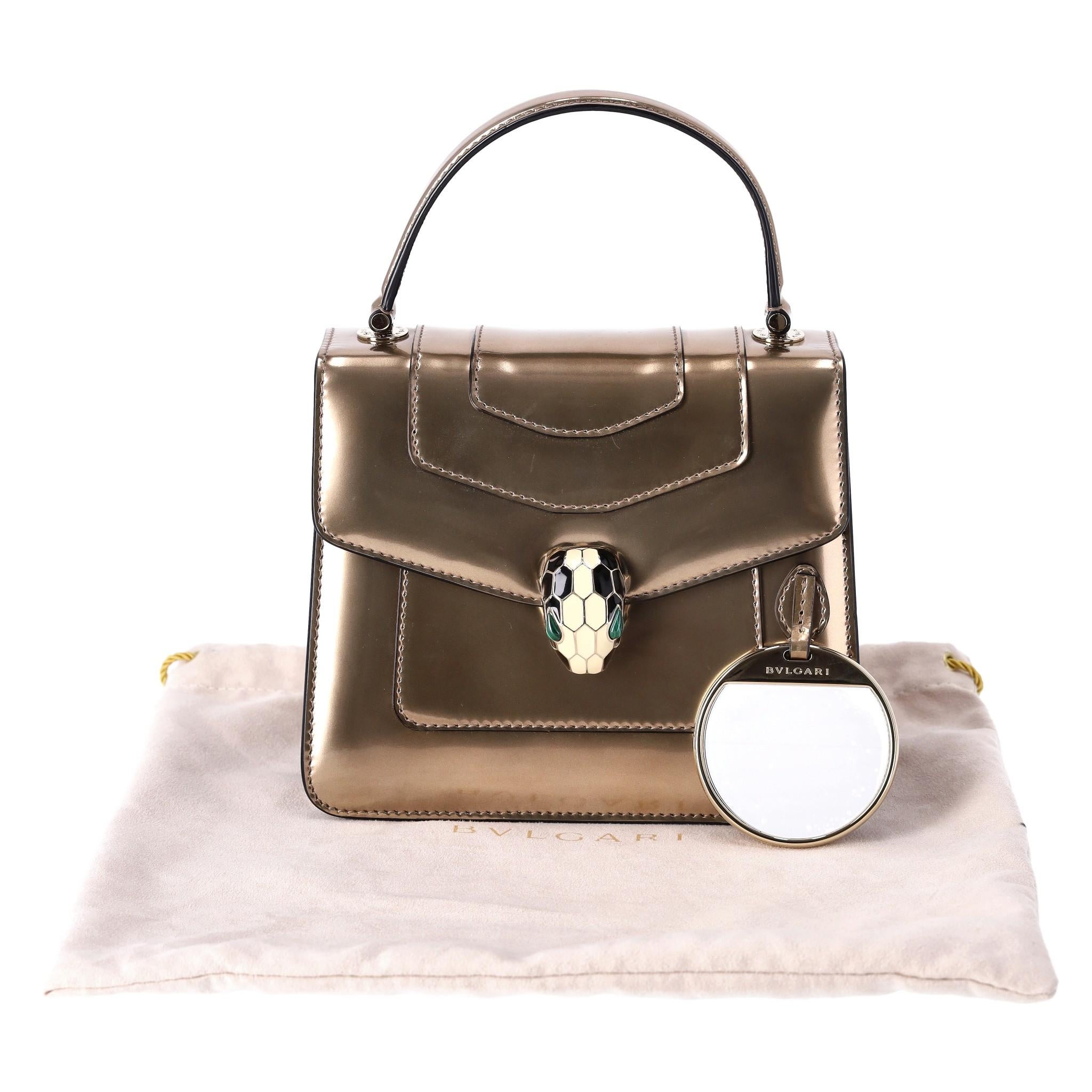 Bvlgari Metallic Leder Serpenti Forever Top Handle Tasche mit Markenspiegel

Bronzefarbene Crossbody-Tasche mit oberem Griff aus Kalbsleder.

Detailliert mit Frontklappe mit emailliertem Schlangenkopfverschluss mit Malachitaugen.

Mit goldener