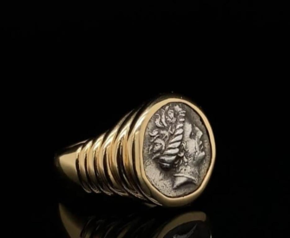 An iconic vintage 'Monete' ring by Bvlgari in 18 karat yellow gold, circa 1970

Set to its centre with an ancient coin dated 4th Century BC within a  grooved, polished yellow gold mount inscribed to its reverse '4th Cent. BC' 'EUBOIA HISTIAIA'

This
