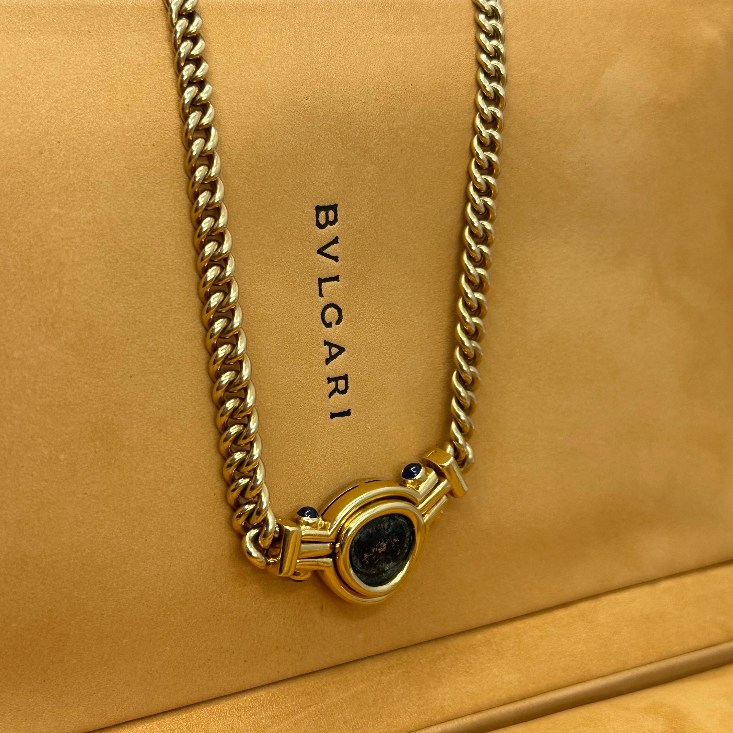 BVLGARI Ancient Coin Necklace
18k Yellow Gold 
18.5 Inches Length
66.3 g Total Weight 
Pendant 25 mm x 20 mm diameter
Four cabochon sapphires bezel set.
Designed as a 18k Yellow Gold Curb Link Necklace the front with bezel set ancient coin, the