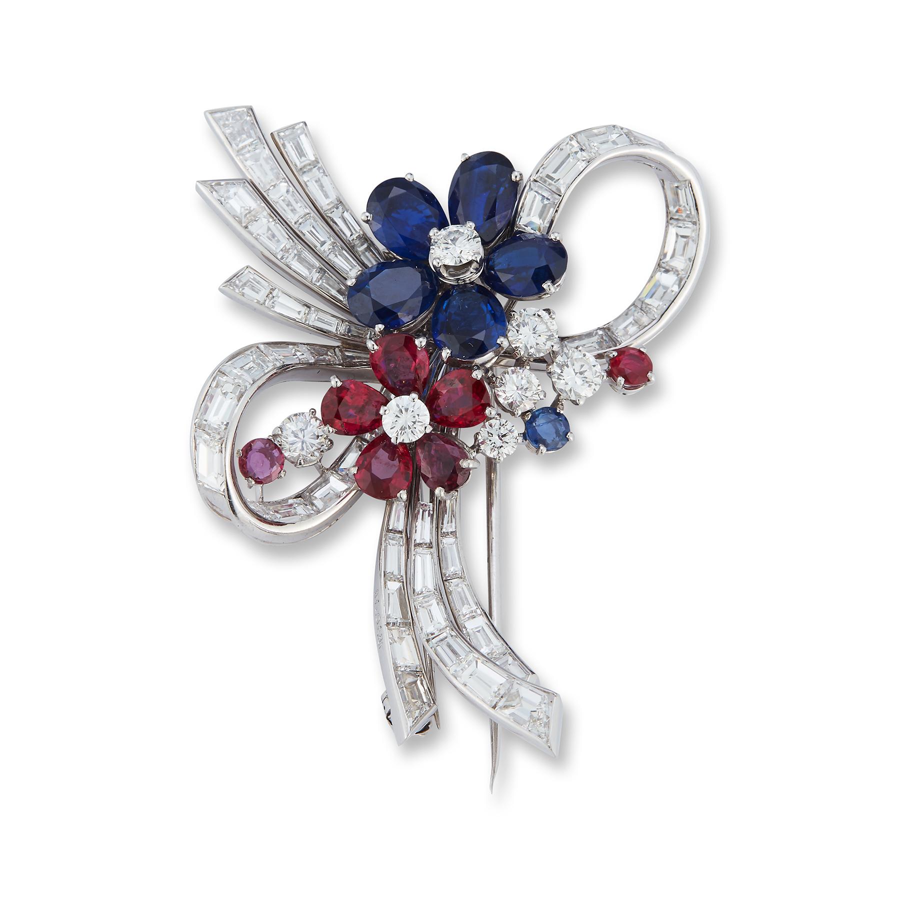 Bulgari Multi Gem & Diamond Floral Brooch set with oval-shaped sapphire and pear-shaped ruby petals with brilliant-cut diamonds.  Round cut ruby and sapphire side stones including a baguette-cut diamond stem and ribbon. Set  in 18K gold and