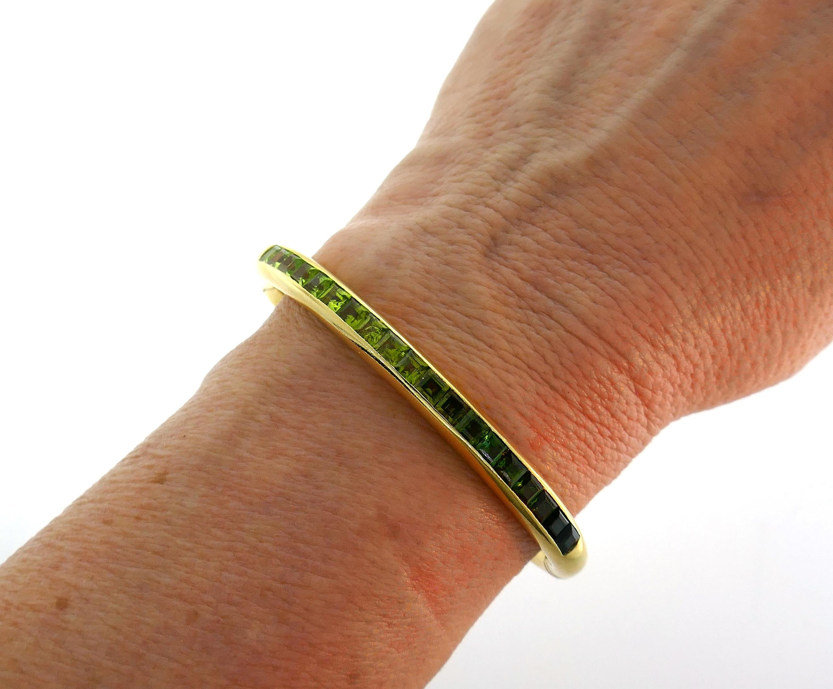 Chic bangle bracelet created by Bvlgari in Italy in the 1980s. Tastefully selected green-hued gemstones with light green through yellowish green to darker bluish green make you keep looking and admiring the bracelet. Elegant and wearable, the bangle