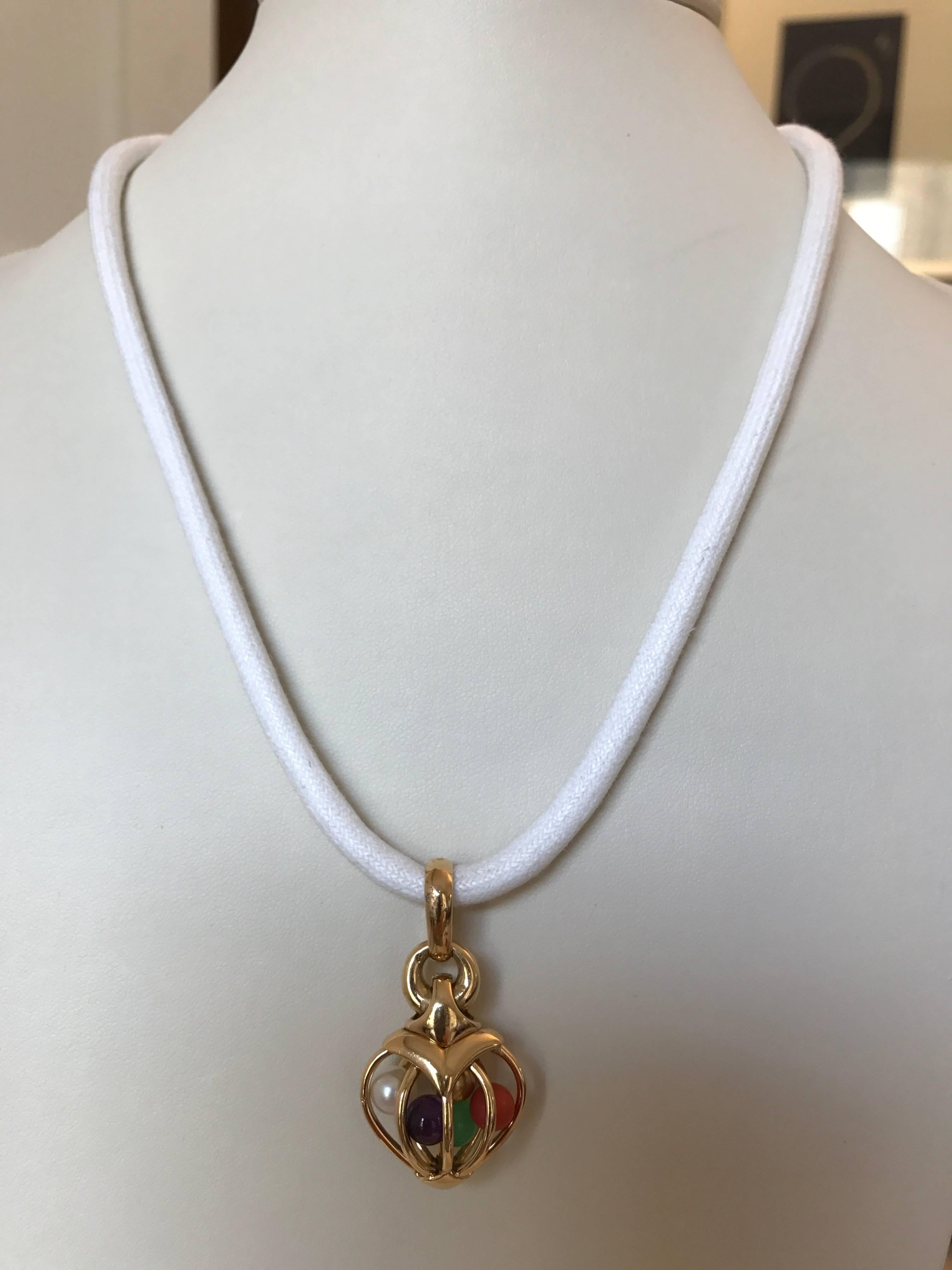 A most unusual and appealing 18ct yellow gold heart-shaped 'cage' pendant containing a pearl, a coral bead, an amethyst bead, a chrysoprase bead and a gold bead signed and numbered by Bvlgari *2337A
