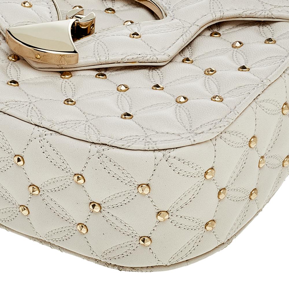 This stunning shoulder bag by Bvlgari is stylish and perfect for day-outs or evenings even. Crafted from quilted leather, it is styled with gold-tone studs, a signature fan-shaped front lock detail, a shoulder strap, and a leather-lined