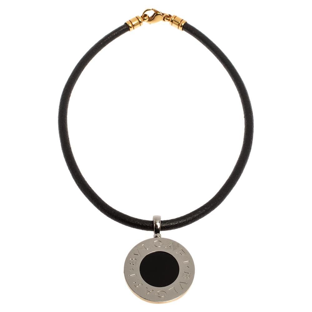 This Bvlgari necklace is a smart accessory to have in your jewelry collection. It features an iconic Bvlgari reversible coin. One side of the coin is crafted from 18K yellow gold while the reverse has a steel coin and onyx stone is stationed at the
