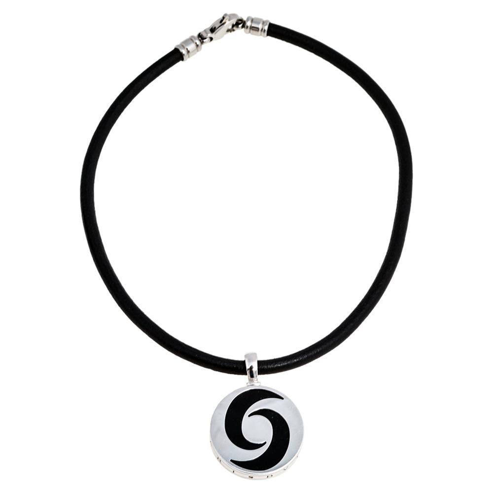 This Bvlgari necklace is a smart accessory to have in your jewelry collection. Crafted from the finest materials, it features a circular pendant set with black onyx and topped with twisted trims, creating an optical illusion. The contours of the